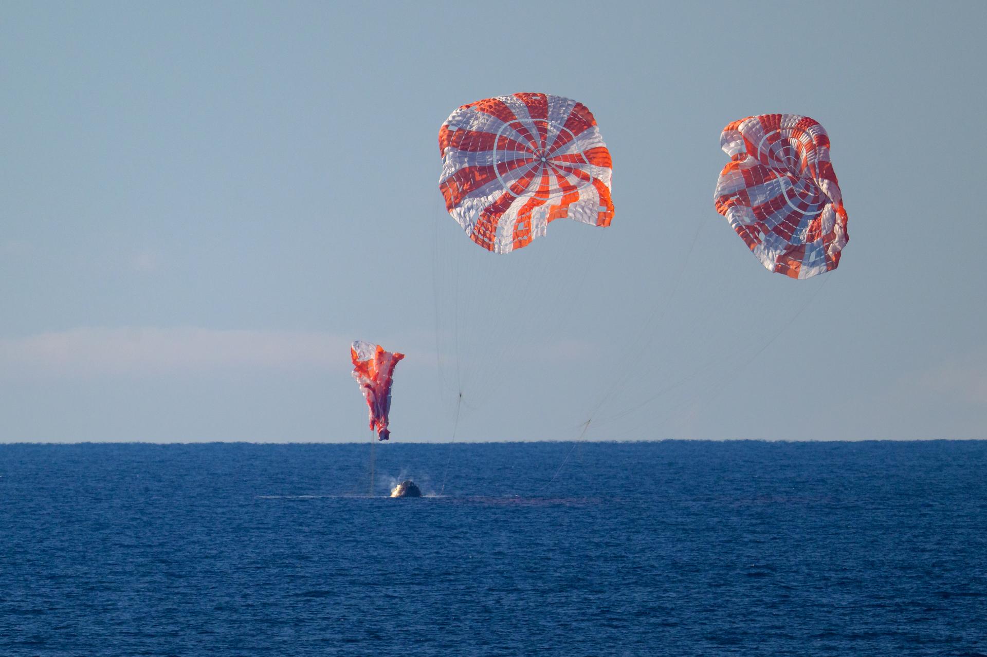 NASA’s Orion spacecraft with Artemis II crewmembers NASA astronauts Reid Wiseman, commander; Victor Glover, pilot; Christina Koch, mission specialist; and CSA (Canadian Space Agency) astronaut Jeremy Hansen, mission specialist aboard is seen as it lands in the Pacific Ocean off the coast of California, Friday, April 10, 2026. NASA’s Artemis II mission took Wiseman, Glover, Koch, and Hansen on a nearly 10-day journey around the Moon and back to Earth. Following a splashdown at 8:07p.m. EDT, NASA, U.S. Navy, and U.S. Air Force teams are working to bring the crewmembers and Orion spacecraft aboard USS John P. Murtha.  Photo Credit: (NASA/Bill Ingalls)