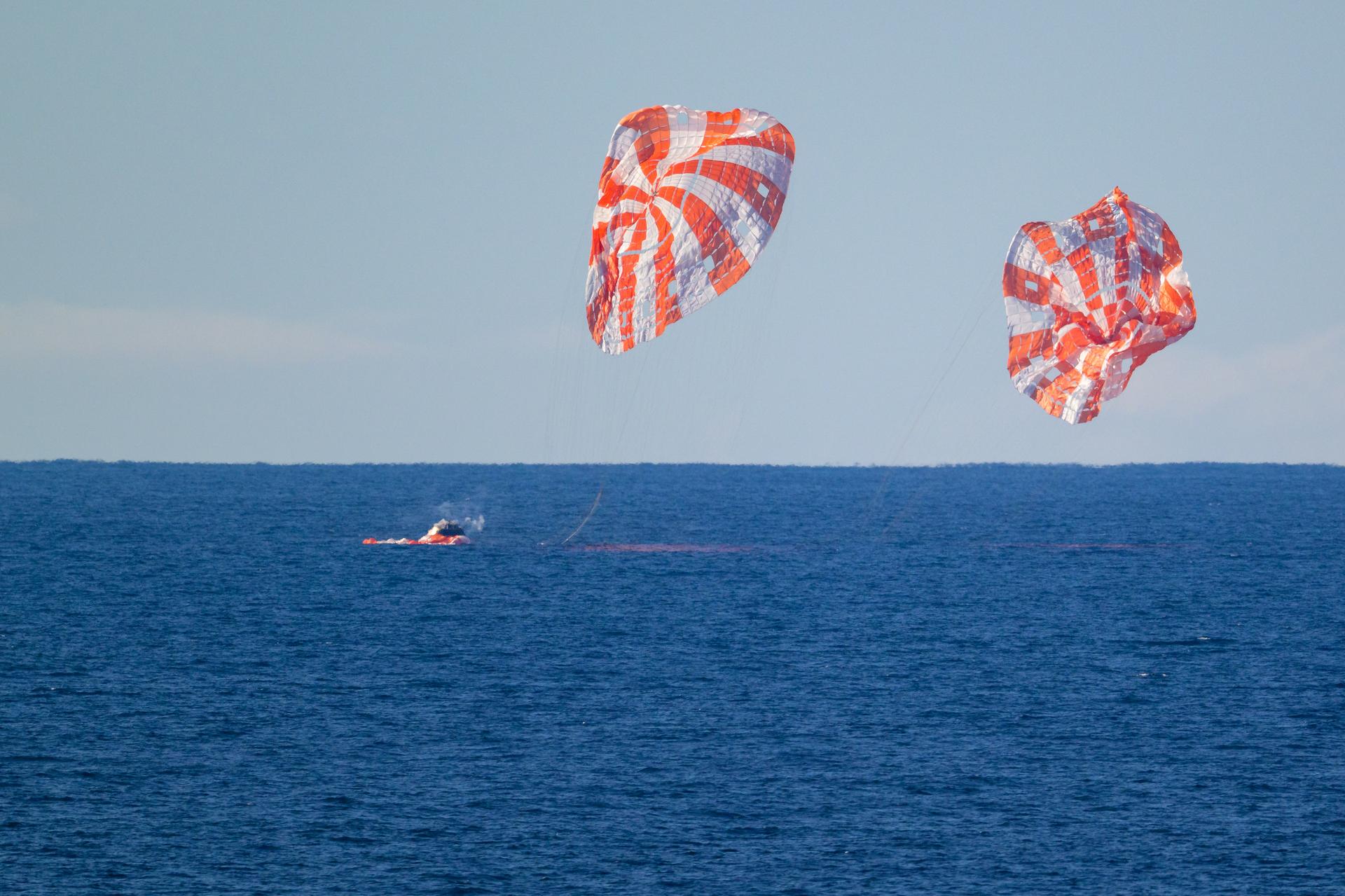 NASA’s Orion spacecraft with Artemis II crewmembers NASA astronauts Reid Wiseman, commander; Victor Glover, pilot; Christina Koch, mission specialist; and CSA (Canadian Space Agency) astronaut Jeremy Hansen, mission specialist aboard is seen as it lands in the Pacific Ocean off the coast of California, Friday, April 10, 2026. NASA’s Artemis II mission took Wiseman, Glover, Koch, and Hansen on a nearly 10-day journey around the Moon and back to Earth. Following a splashdown at 8:07p.m. EDT, NASA, U.S. Navy, and U.S. Air Force teams are working to bring the crewmembers and Orion spacecraft aboard USS John P. Murtha.  Photo Credit: (NASA/Bill Ingalls)