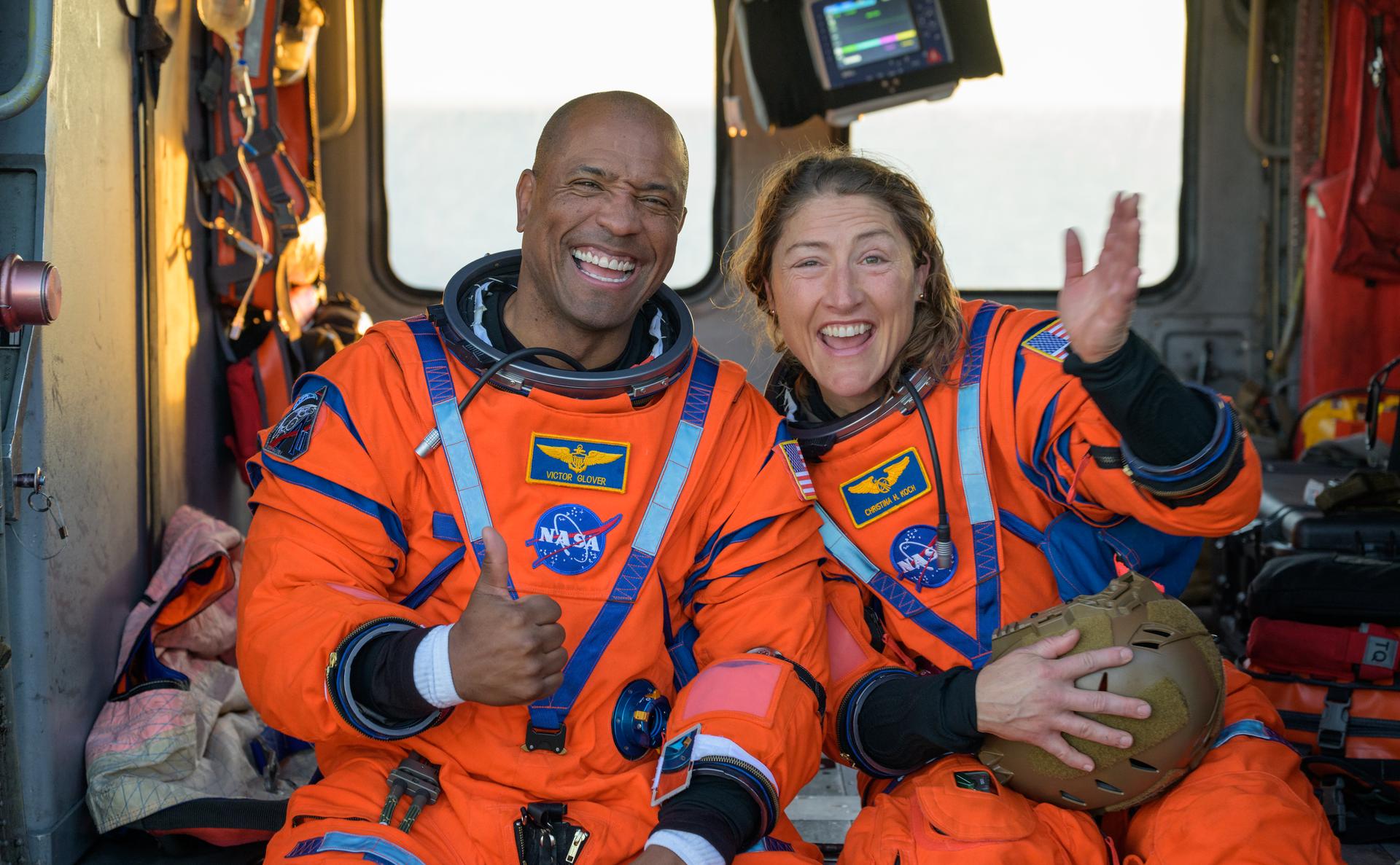 NASA astronaut Victor Glover, Artemis II pilot, left, and NASA astronaut Christina Koch, Artemis II mission specialist are seen sitting on a Navy MH-60 Seahawk from Helicopter Sea Combat Squadron (HSC) 23 on the flight deck of USS John P. Murtha after they and fellow crewmates CSA (Canadian Space Agency) astronaut Jeremy Hansen, Artemis II mission specialist, and NASA astronaut Reid Wiseman, Artemis II commander, were extracted from their Orion spacecraft after splashdown, Friday, April 10, 2026, in the Pacific Ocean off the coast of California. NASA’s Artemis II mission took the quartet on a nearly 10-day journey around the Moon and back to Earth. Following a splashdown at 5:07 p.m. PDT (8:07 p.m. EDT), NASA, U.S. Navy, and U.S. Air Force teams are working to bring the Orion spacecraft aboard the recovery ship. Photo Credit: (NASA/Bill Ingalls)