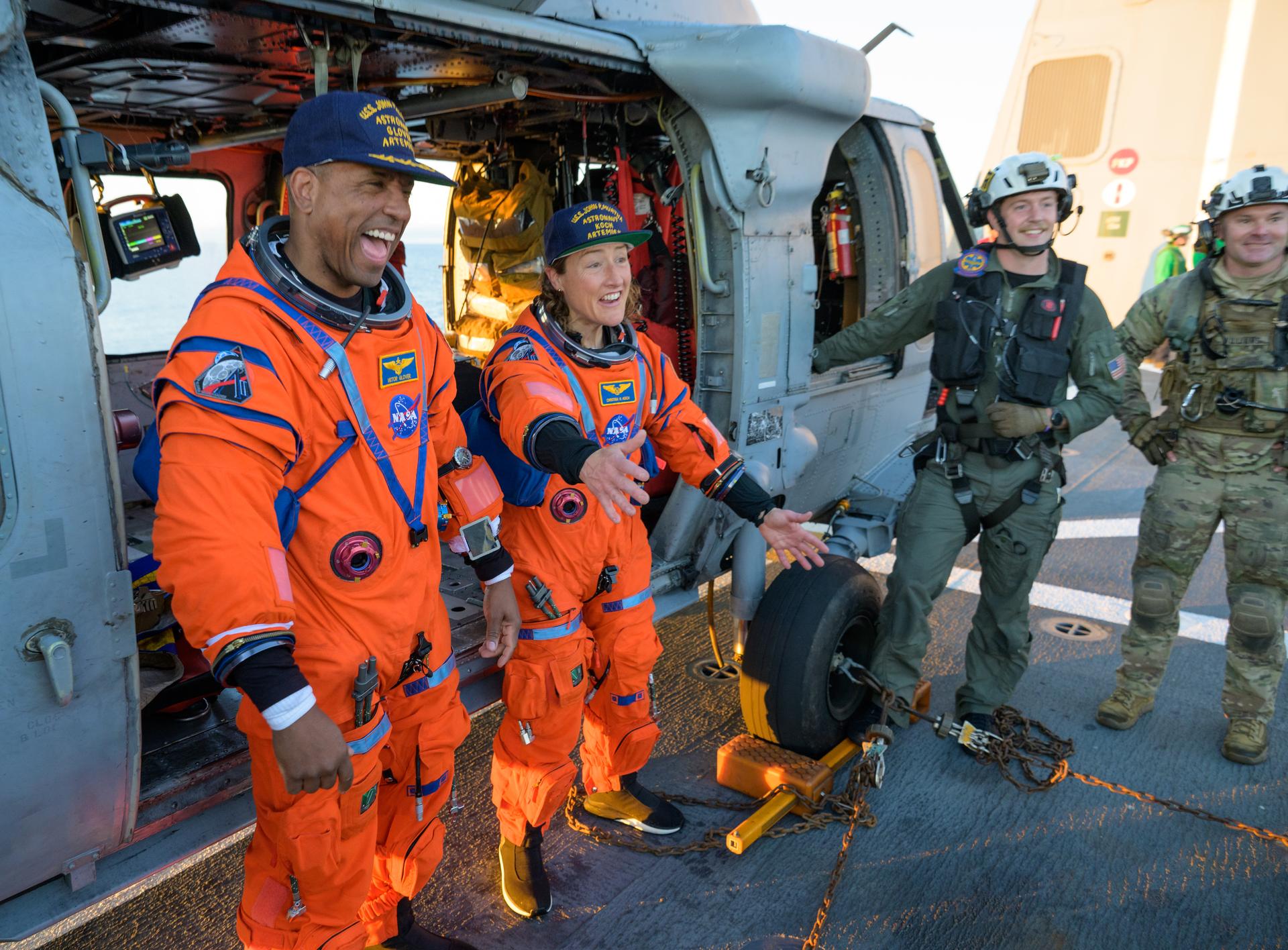 NASA astronaut Victor Glover, Artemis II pilot, left, and NASA astronaut Christina Koch, Artemis II mission specialist are seen sitting on a Navy MH-60 Seahawk from Helicopter Sea Combat Squadron (HSC) 23 on the flight deck of USS John P. Murtha after they and fellow crewmates CSA (Canadian Space Agency) astronaut Jeremy Hansen, Artemis II mission specialist, and NASA astronaut Reid Wiseman, Artemis II commander, were extracted from their Orion spacecraft after splashdown, Friday, April 10, 2026, in the Pacific Ocean off the coast of California. NASA’s Artemis II mission took the quartet on a nearly 10-day journey around the Moon and back to Earth. Following a splashdown at 5:07 p.m. PDT (8:07 p.m. EDT), NASA, U.S. Navy, and U.S. Air Force teams are working to bring the Orion spacecraft aboard the recovery ship. Photo Credit: (NASA/Bill Ingalls)