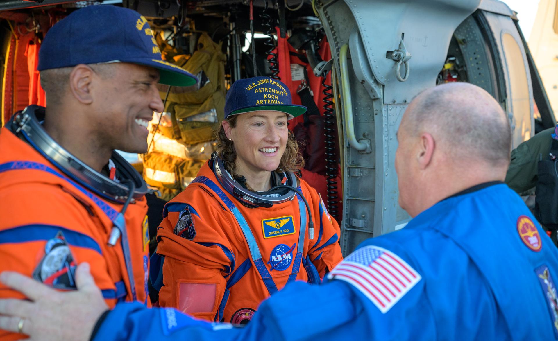 NASA astronaut Victor Glover, Artemis II pilot, left, and NASA astronaut Christina Koch, Artemis II mission specialist are welcomed home by Scott Tingle, Chief of the Astronaut Office next to a Navy MH-60 Seahawk from Helicopter Sea Combat Squadron (HSC) 23 on the flight deck of USS John P. Murtha after they and fellow crewmates CSA (Canadian Space Agency) astronaut Jeremy Hansen, Artemis II mission specialist, and NASA astronaut Reid Wiseman, Artemis II commander, were extracted from their Orion spacecraft after splashdown, Friday, April 10, 2026, in the Pacific Ocean off the coast of California. NASA’s Artemis II mission took the quartet on a nearly 10-day journey around the Moon and back to Earth. Following a splashdown at 5:07 p.m. PDT (8:07 p.m. EDT), NASA, U.S. Navy, and U.S. Air Force teams are working to bring the Orion spacecraft aboard the recovery ship. Photo Credit: (NASA/Bill Ingalls)