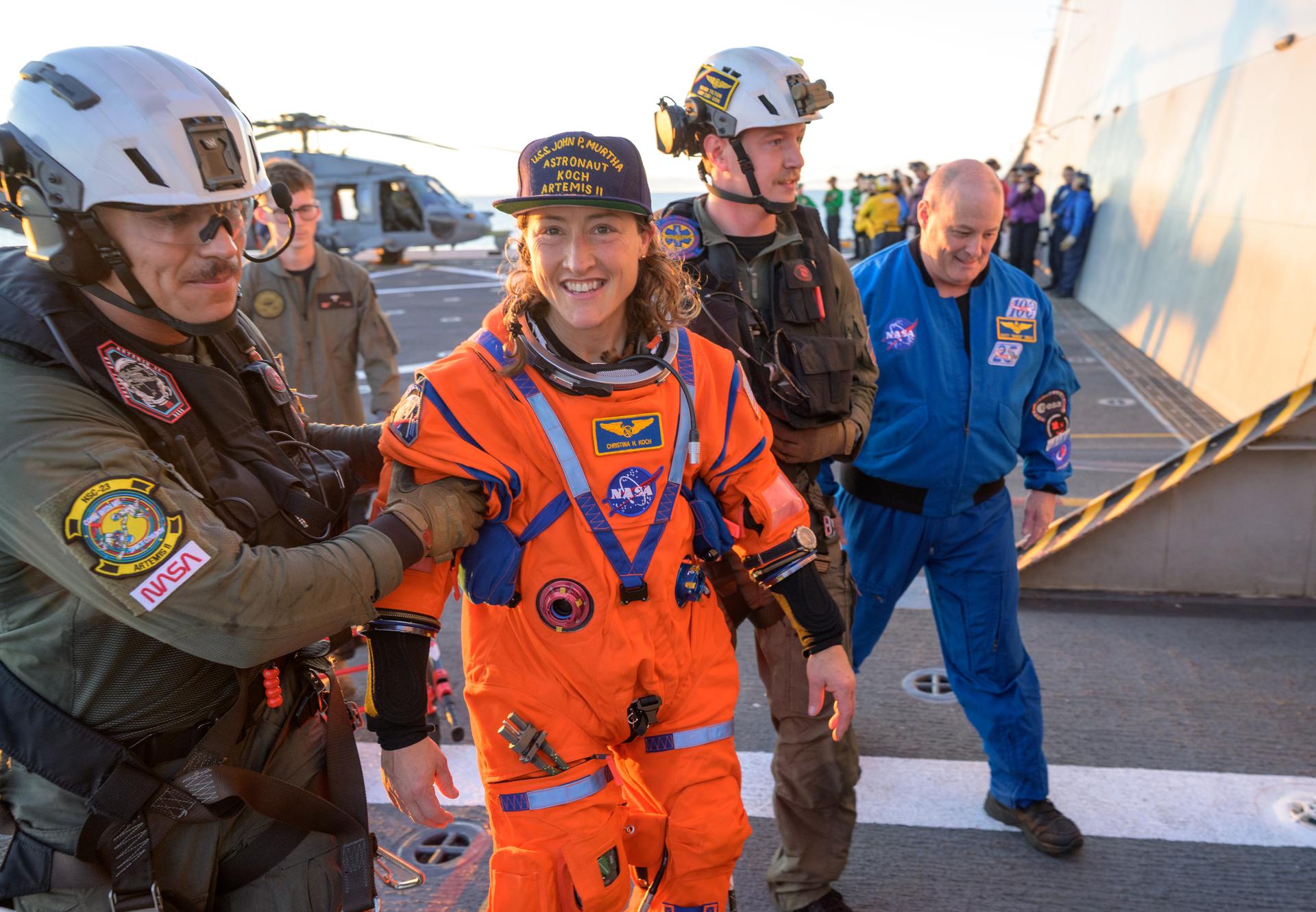 NASA astronaut Christina Koch, Artemis II mission specialist is assisted off the flight deck after arriving aboard USS John P. Murtha after she and fellow crewmates NASA astronauts Reid Wiseman, commander; Victor Glover, pilot; and CSA (Canadian Space Agency) astronaut Jeremy Hansen, mission specialist were extracted from their Orion spacecraft after splashdown, Friday, April 10, 2026, in the Pacific Ocean off the coast of California. NASA’s Artemis II mission took the quartet on a 10-day journey around the Moon and back to Earth. Following a splashdown at , NASA and U.S. military teams are working to bring the crewmembers and Orion spacecraft aboard the recovery ship. Photo Credit: (NASA/Bill Ingalls)