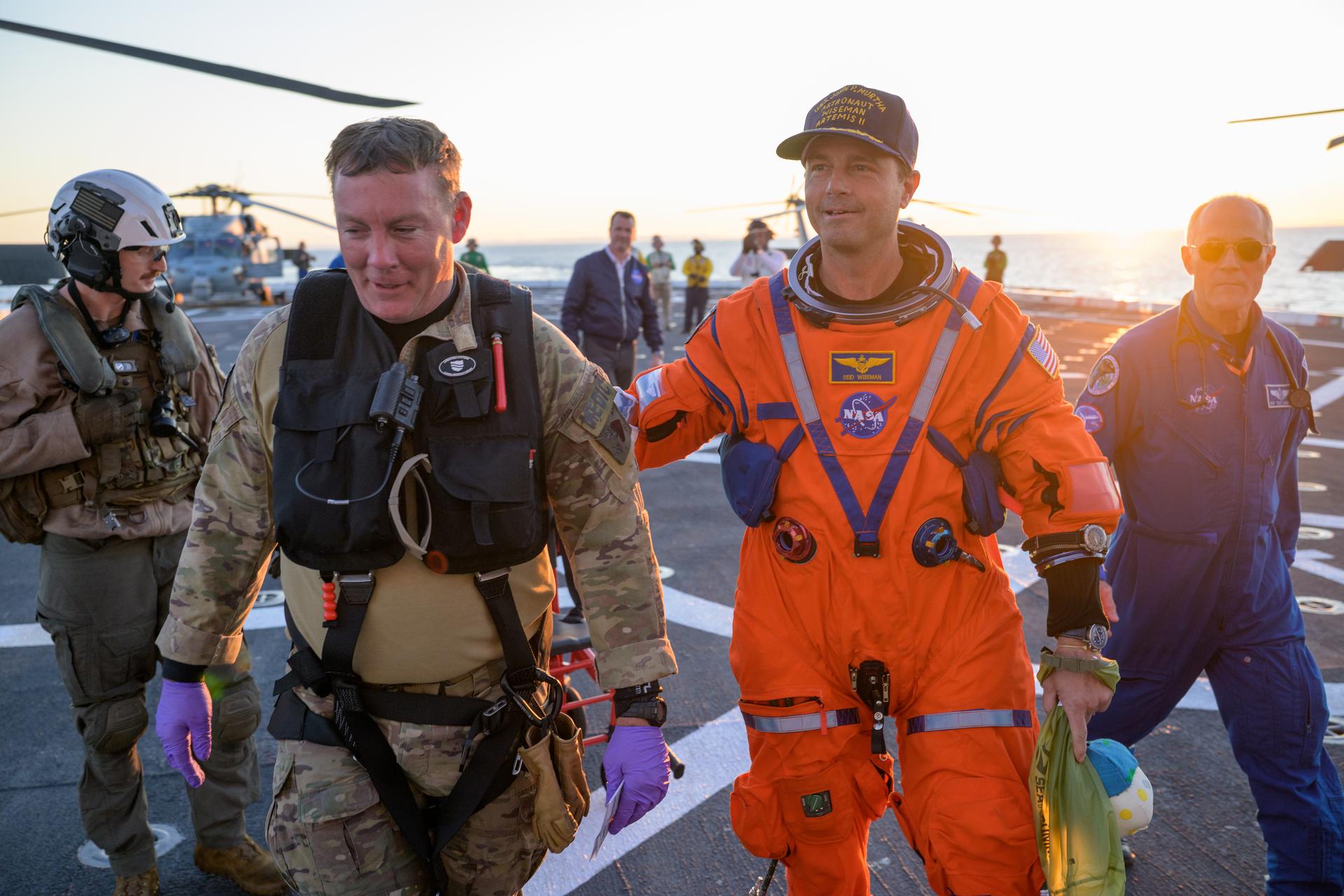 NASA astronaut Reid Wiseman, Artemis II commander is assisted off the flight deck after arriving aboard USS John P. Murtha after he and fellow crewmates NASA Astronauts Victor Glover, Christina Koch, and CSA (Canadian Space Agency) astronaut Jeremy Hansen, were extracted from their Orion spacecraft after splashdown, Friday, April 10, 2026, in the Pacific Ocean off the coast of California. NASA’s Artemis II mission took the quartet on a 10-day journey around the Moon and back to Earth. Following a splashdown at , NASA and U.S. military teams are working to bring the crewmembers and Orion spacecraft aboard the recovery ship. Photo Credit: (NASA/Bill Ingalls)