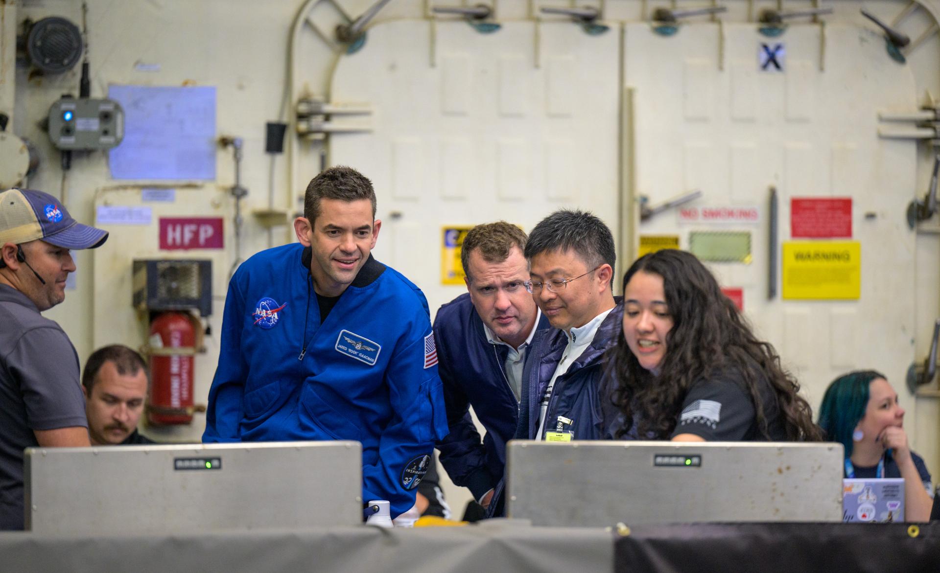 NASA Administrator Jared Isaacman, left, and Michael Altenhofen, senior advisor to the NASA Administrator, talk with team members as they prepare to recover NASA’s Orion spacecraft into the well deck of USS John P. Murtha in the Pacific Ocean off the coast of California, Friday, April 10, 2026. NASA’s Artemis II mission, which took NASA astronauts Reid Wiseman, commander; Victor Glover, pilot; Christina Koch, mission specialist; and CSA (Canadian Space Agency) astronaut Jeremy Hansen, mission specialist on a nearly 10-day journey around the Moon and back to Earth, splashed down at 5:07 p.m. PDT (8:07 p.m. EDT).  Photo Credit: (NASA/Bill Ingalls)