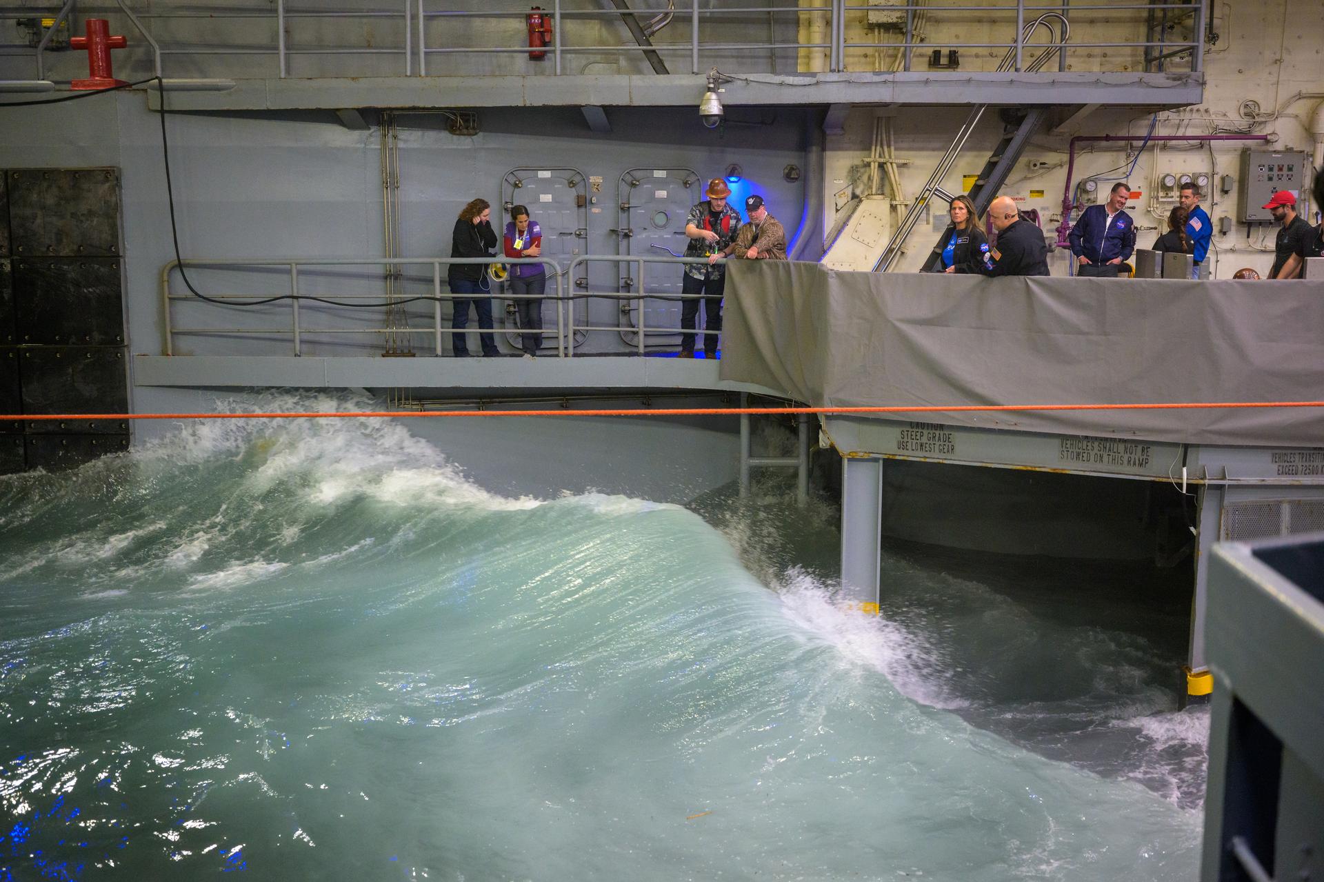 NASA’s Landing and Recovery team, along with U.S. Navy personnel work to recover the spacecraft into the well deck of USS John P. Murtha in the Pacific Ocean off the coast of California, Friday, April 10, 2026. NASA’s Artemis II mission, which took NASA astronauts Reid Wiseman, commander; Victor Glover, pilot; Christina Koch, mission specialist; and CSA (Canadian Space Agency) astronaut Jeremy Hansen, mission specialist on a 10-day journey around the Moon and back to Earth, splashed down at at 5:07 p.m. PDT (8:07 p.m. EDT).  Photo Credit: (NASA/Bill Ingalls)
