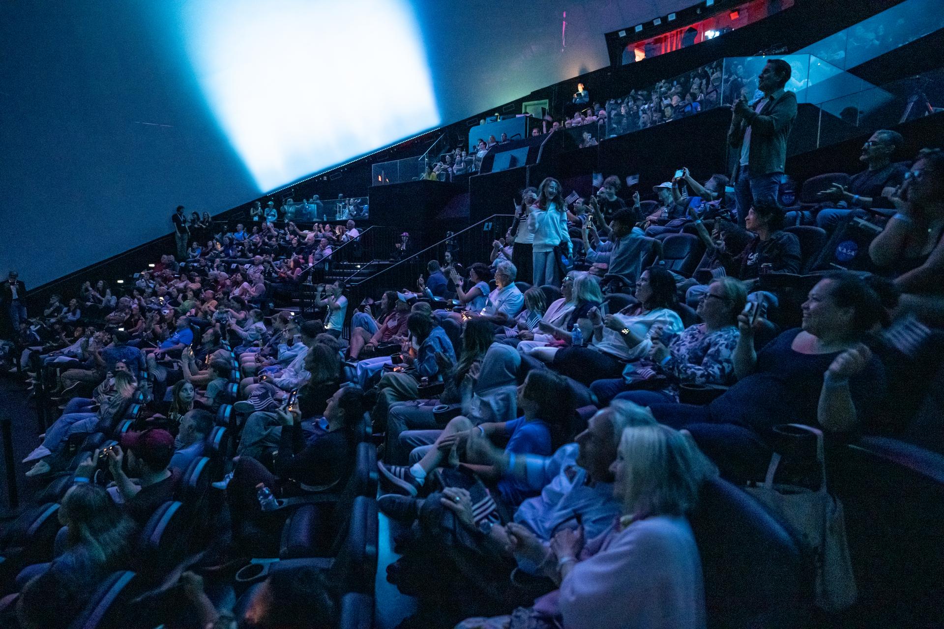 Guests at the Fleet Science Center in San Diego, California watch the live broadcast of NASA’s Orion spacecraft with Artemis II crew members NASA astronauts Reid Wiseman, commander; Victor Glover, pilot; Christina Koch, mission specialist; and CSA (Canadian Space Agency) astronaut Jeremy Hansen, mission specialist aboard landing in the Pacific Ocean off the coast of California, Friday, April 10, 2026. NASA’s Artemis II mission took Wiseman, Glover, Koch, and Hansen on a 10-day journey around the Moon and back to Earth. Photo Credit: (NASA/Keegan Barber)