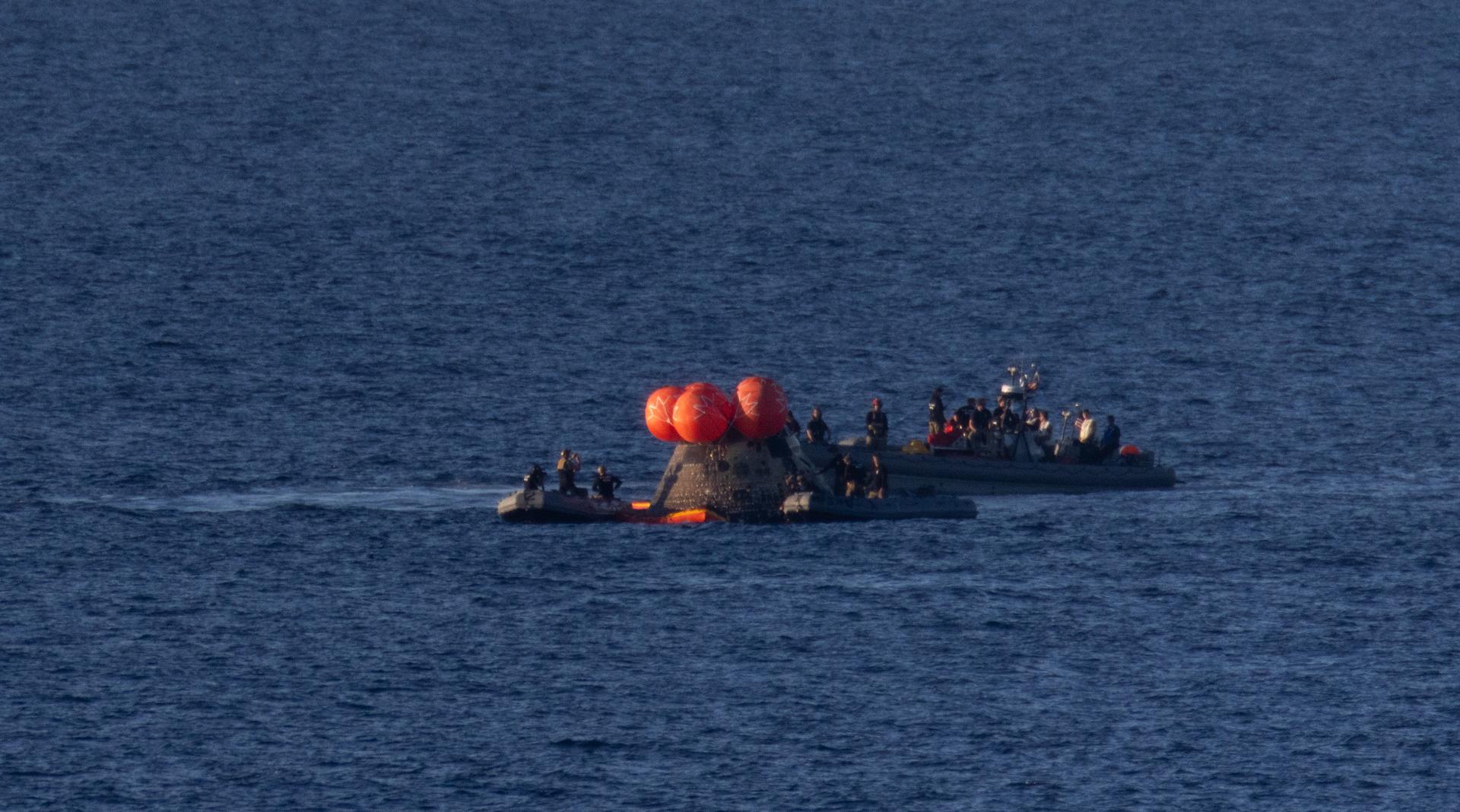 NASA’s Orion spacecraft is seen as recovery teams work to secure the spacecraft ahead of transferring Artemis II crewmembers NASA astronauts Reid Wiseman, commander; Victor Glover, pilot; Christina Koch, mission specialist; and CSA (Canadian Space Agency) astronaut Jeremy Hansen, mission specialist to USS John P. Murtha in the Pacific Ocean off the coast of California, Friday, April 10, 2026. NASA’s Artemis II mission took Wiseman, Glover, Koch, and Hansen on a nearly 10-day journey around the Moon and back to Earth. Following a  splashdown at 5:07 p.m. PDT (8:07 p.m. EDT), NASA, U.S. Navy, and U.S. Air Force teams are working to bring the crewmembers and Orion spacecraft aboard USS John P. Murtha.  Photo Credit: (NASA/Joel Kowsky)