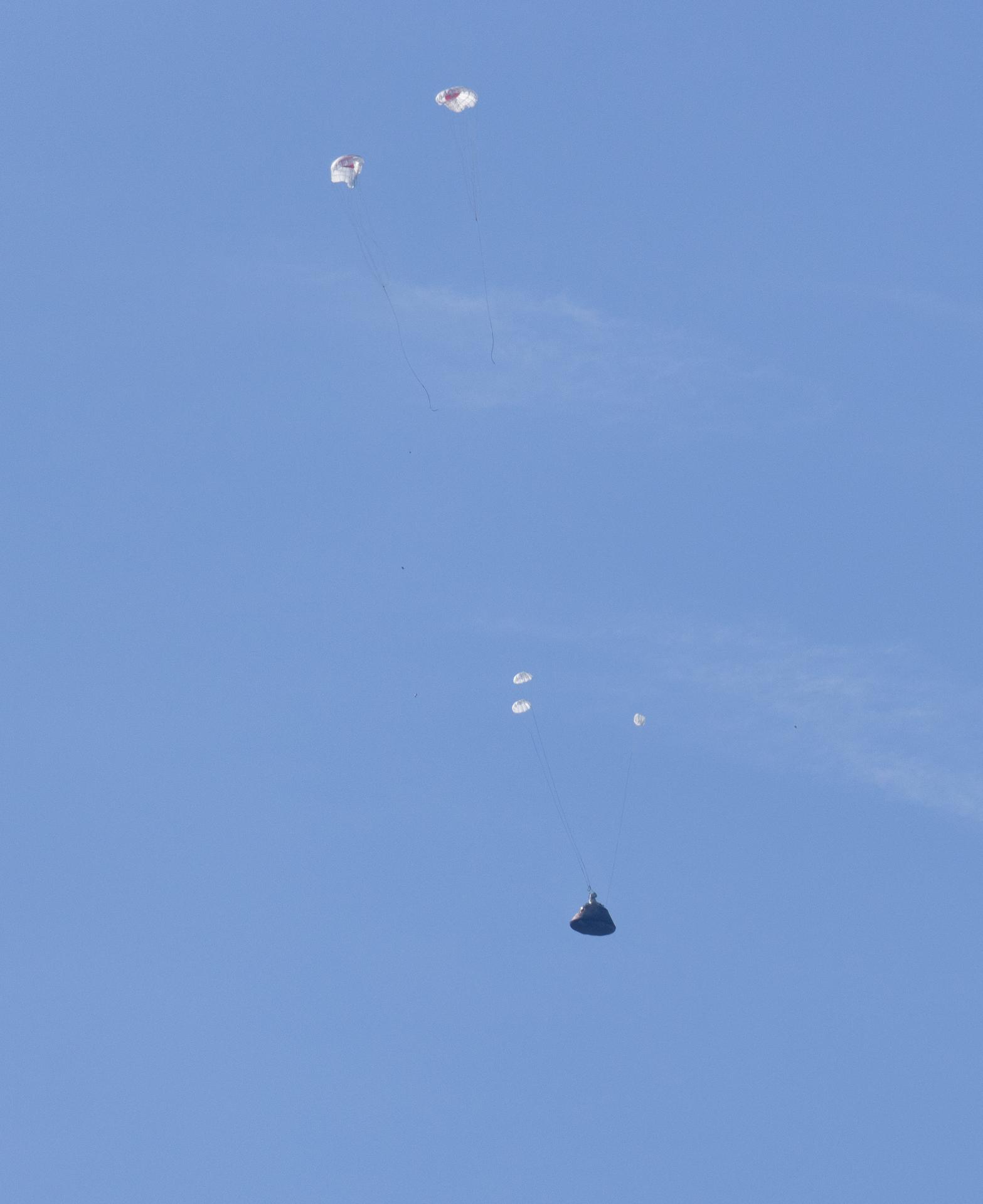 NASA’s Orion spacecraft with Artemis II crewmembers NASA astronauts Reid Wiseman, commander; Victor Glover, pilot; Christina Koch, mission specialist; and CSA (Canadian Space Agency) astronaut Jeremy Hansen, mission specialist aboard is seen as the main parachutes begin to deploy as it lands in the Pacific Ocean off the coast of California, Friday, April 10, 2026. NASA’s Artemis II mission took Wiseman, Glover, Koch, and Hansen on a nearly 10-day journey around the Moon and back to Earth. Following a splashdown at 5:07 p.m. PDT (8:07 p.m. EDT), NASA, U.S. Navy, and U.S. Air Force teams are working to bring the crewmembers and Orion spacecraft aboard USS John P. Murtha.  Photo Credit: (NASA/Joel Kowsky)