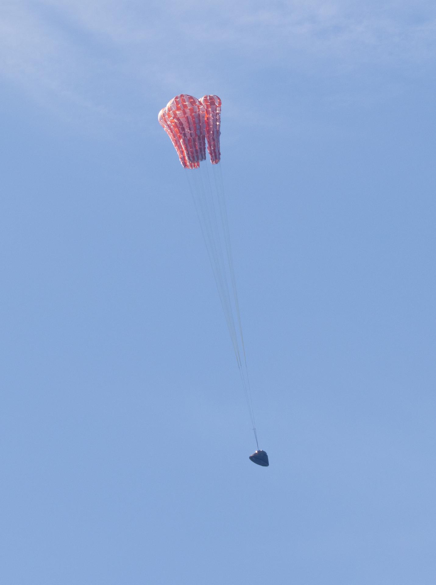 NASA’s Orion spacecraft with Artemis II crewmembers NASA astronauts Reid Wiseman, commander; Victor Glover, pilot; Christina Koch, mission specialist; and CSA (Canadian Space Agency) astronaut Jeremy Hansen, mission specialist aboard is seen as the main parachutes begin to deploy as it lands in the Pacific Ocean off the coast of California, Friday, April 10, 2026. NASA’s Artemis II mission took Wiseman, Glover, Koch, and Hansen on a nearly 10-day journey around the Moon and back to Earth. Following a splashdown at 5:07 p.m. PDT (8:07 p.m. EDT), NASA, U.S. Navy, and U.S. Air Force teams are working to bring the crewmembers and Orion spacecraft aboard USS John P. Murtha.  Photo Credit: (NASA/Joel Kowsky)