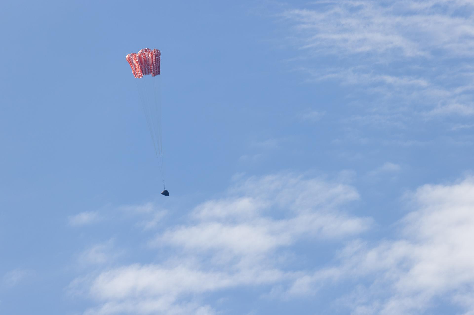NASA’s Orion spacecraft with Artemis II crewmembers NASA astronauts Reid Wiseman, commander; Victor Glover, pilot; Christina Koch, mission specialist; and CSA (Canadian Space Agency) astronaut Jeremy Hansen, mission specialist aboard is seen as the main parachutes begin to deploy as it lands in the Pacific Ocean off the coast of California, Friday, April 10, 2026. NASA’s Artemis II mission took Wiseman, Glover, Koch, and Hansen on a nearly 10-day journey around the Moon and back to Earth. Following a splashdown at 5:07 p.m. PDT (8:07 p.m. EDT), NASA, U.S. Navy, and U.S. Air Force teams are working to bring the crewmembers and Orion spacecraft aboard USS John P. Murtha.  Photo Credit: (NASA/Joel Kowsky)