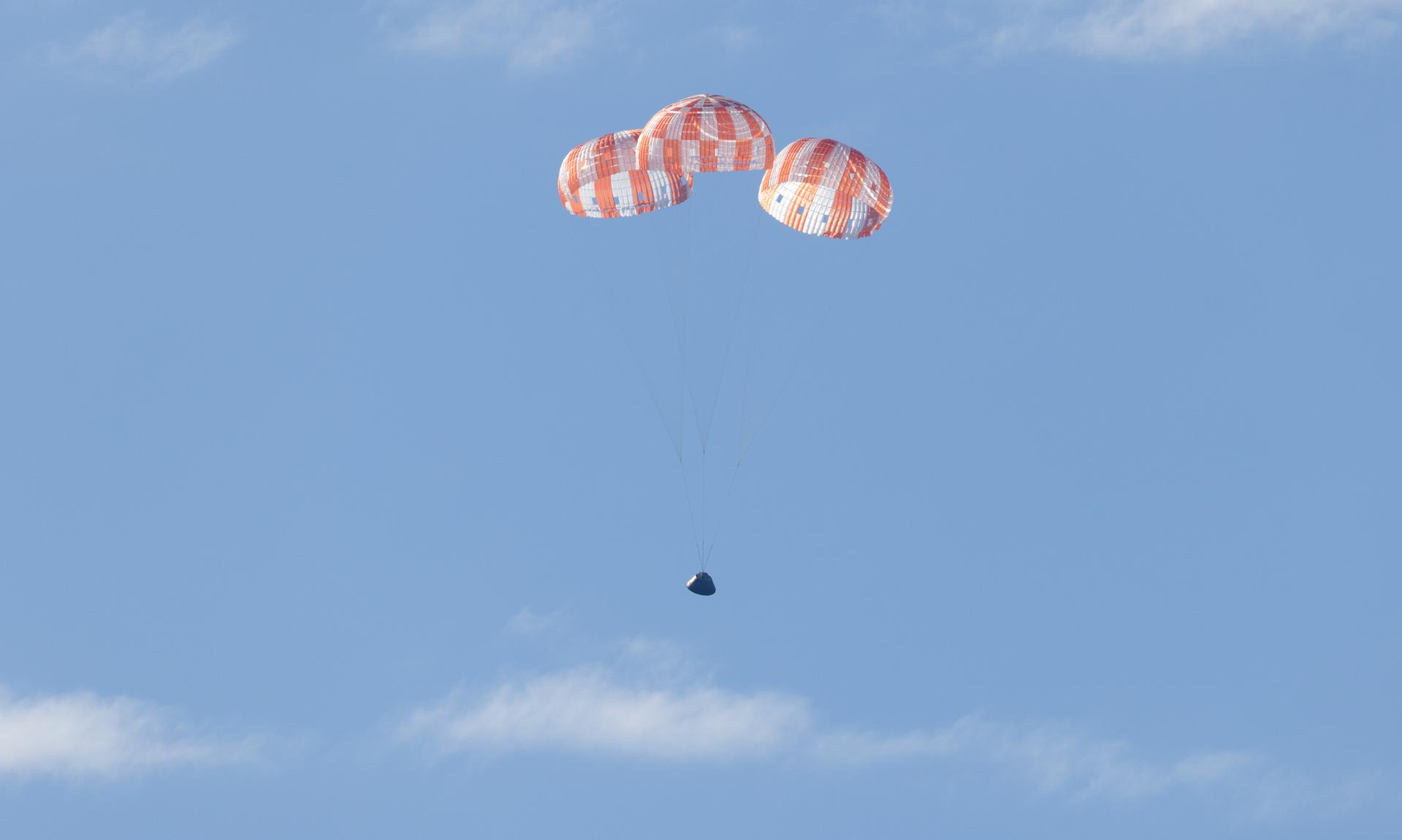 NASA’s Orion spacecraft with Artemis II crewmembers NASA astronauts Reid Wiseman, commander; Victor Glover, pilot; Christina Koch, mission specialist; and CSA (Canadian Space Agency) astronaut Jeremy Hansen, mission specialist aboard is seen under parachutes as it lands in the Pacific Ocean off the coast of California, Friday, April 10, 2026. NASA’s Artemis II mission took Wiseman, Glover, Koch, and Hansen on a nearly 10-day journey around the Moon and back to Earth. Following a splashdown at 5:07 p.m. PDT (8:07 p.m. EDT), NASA, U.S. Navy, and U.S. Air Force teams are working to bring the crewmembers and Orion spacecraft aboard USS John P. Murtha.  Photo Credit: (NASA/Joel Kowsky)