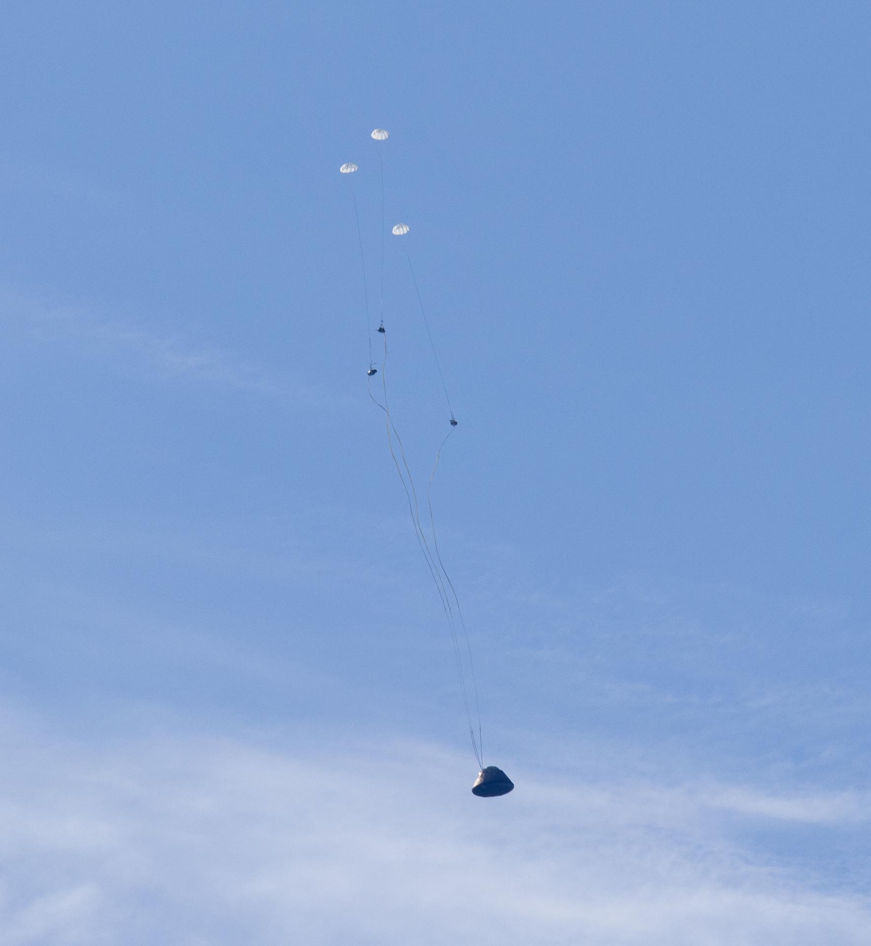 NASA’s Orion spacecraft with Artemis II crewmembers NASA astronauts Reid Wiseman, commander; Victor Glover, pilot; Christina Koch, mission specialist; and CSA (Canadian Space Agency) astronaut Jeremy Hansen, mission specialist aboard is seen as the main parachutes begin to deploy as it lands in the Pacific Ocean off the coast of California, Friday, April 10, 2026. NASA’s Artemis II mission took Wiseman, Glover, Koch, and Hansen on a nearly 10-day journey around the Moon and back to Earth. Following a splashdown at 5:07 p.m. PDT (8:07 p.m. EDT), NASA, U.S. Navy, and U.S. Air Force teams are working to bring the crewmembers and Orion spacecraft aboard USS John P. Murtha.  Photo Credit: (NASA/Joel Kowsky)