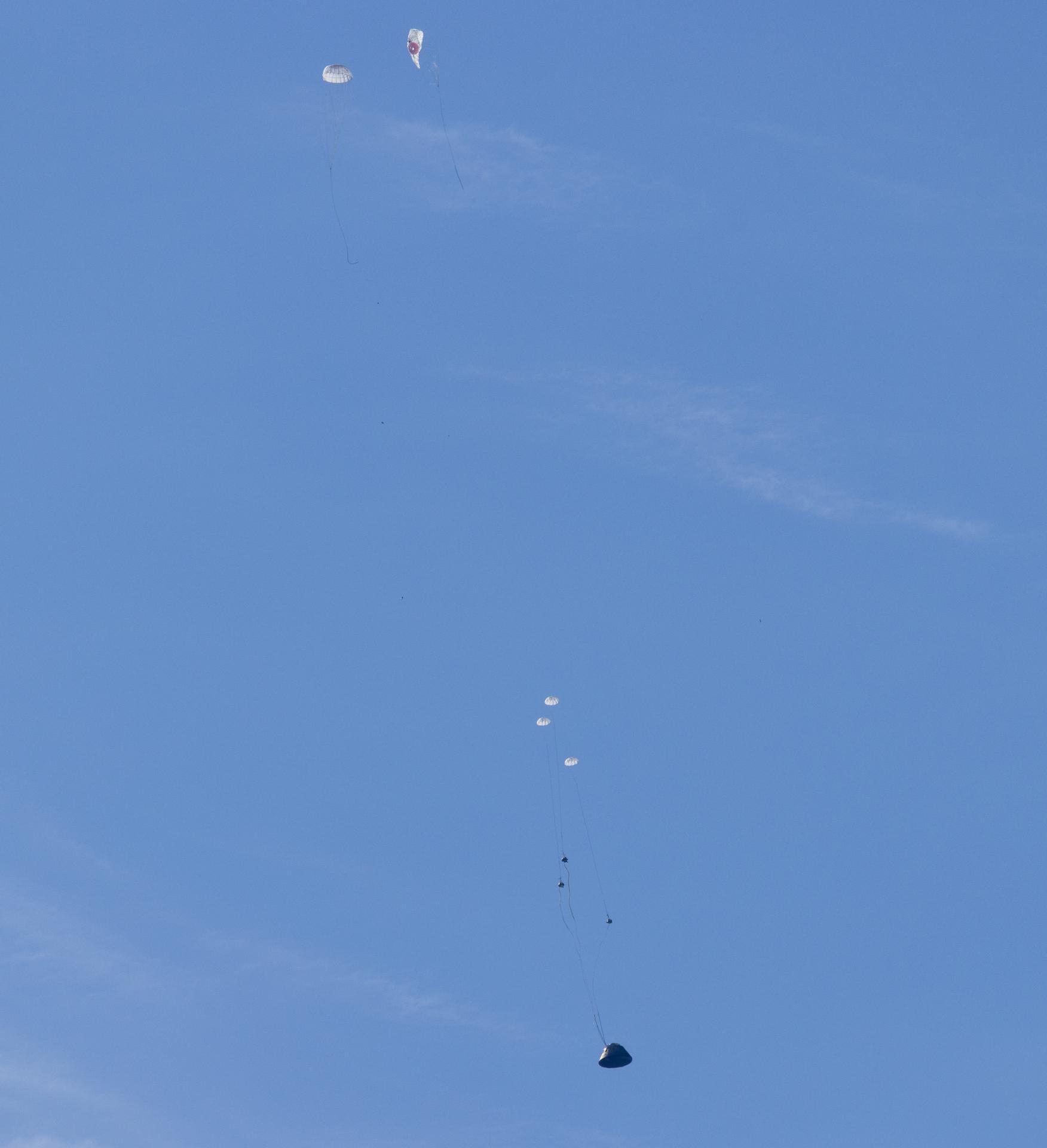 NASA’s Orion spacecraft with Artemis II crewmembers NASA astronauts Reid Wiseman, commander; Victor Glover, pilot; Christina Koch, mission specialist; and CSA (Canadian Space Agency) astronaut Jeremy Hansen, mission specialist aboard is seen as the main parachutes begin to deploy as it lands in the Pacific Ocean off the coast of California, Friday, April 10, 2026. NASA’s Artemis II mission took Wiseman, Glover, Koch, and Hansen on a nearly 10-day journey around the Moon and back to Earth. Following a splashdown at 5:07 p.m. PDT (8:07 p.m. EDT), NASA, U.S. Navy, and U.S. Air Force teams are working to bring the crewmembers and Orion spacecraft aboard USS John P. Murtha.  Photo Credit: (NASA/Joel Kowsky)