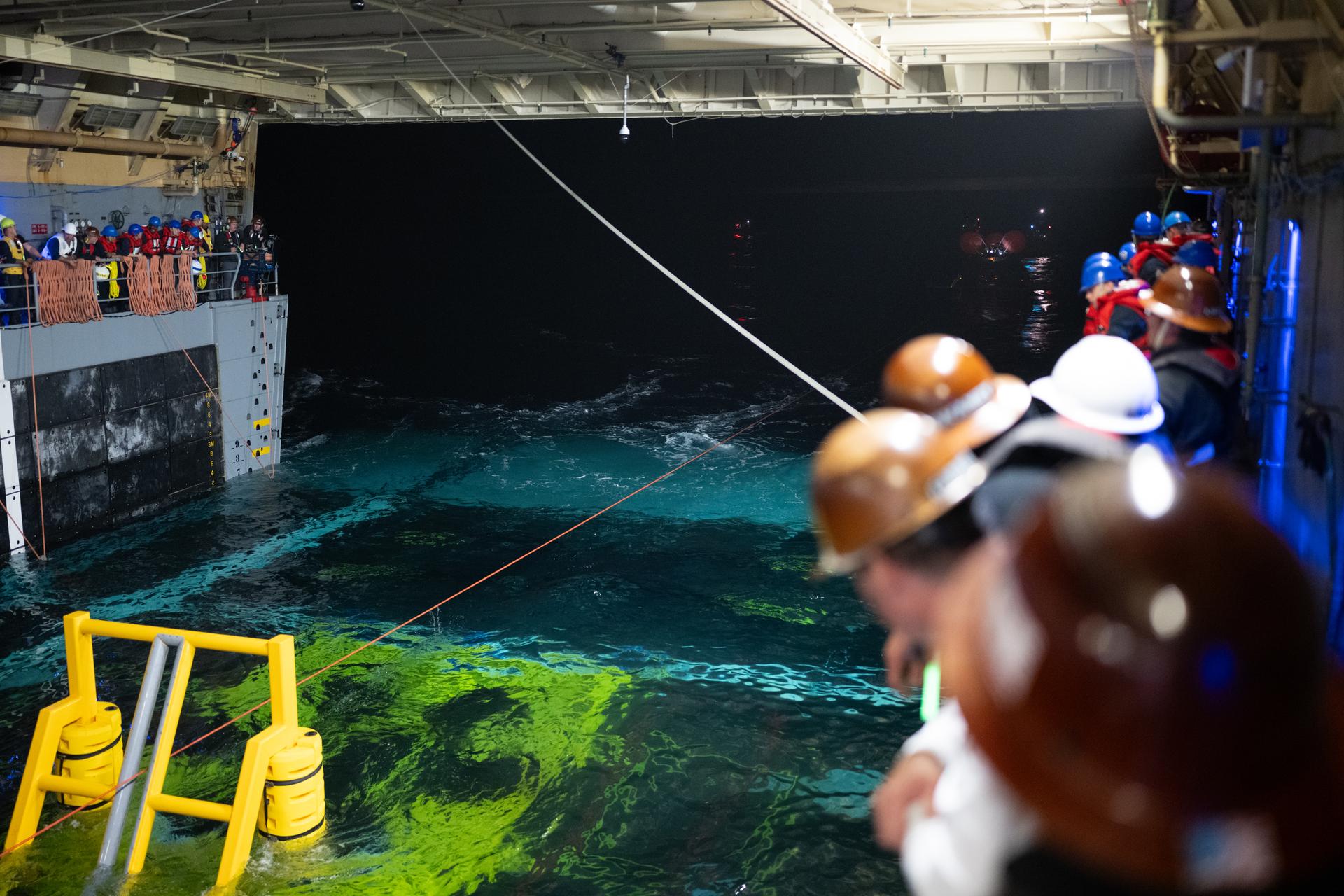 NASA’s Orion spacecraft is seen as the agency’s Landing and Recovery team, along with U.S. Navy personnel work to recover the spacecraft into the well deck of USS John P. Murtha in the Pacific Ocean off the coast of California, Friday, April 10, 2026. NASA’s Artemis II mission, which took NASA astronauts Reid Wiseman, commander; Victor Glover, pilot; Christina Koch, mission specialist; and CSA (Canadian Space Agency) astronaut Jeremy Hansen, mission specialist on a nearly 10-day journey around the Moon and back to Earth, splashed down at 5:07 p.m. PDT (8:07 p.m. EDT).  Photo Credit: (NASA/Joel Kowsky)
