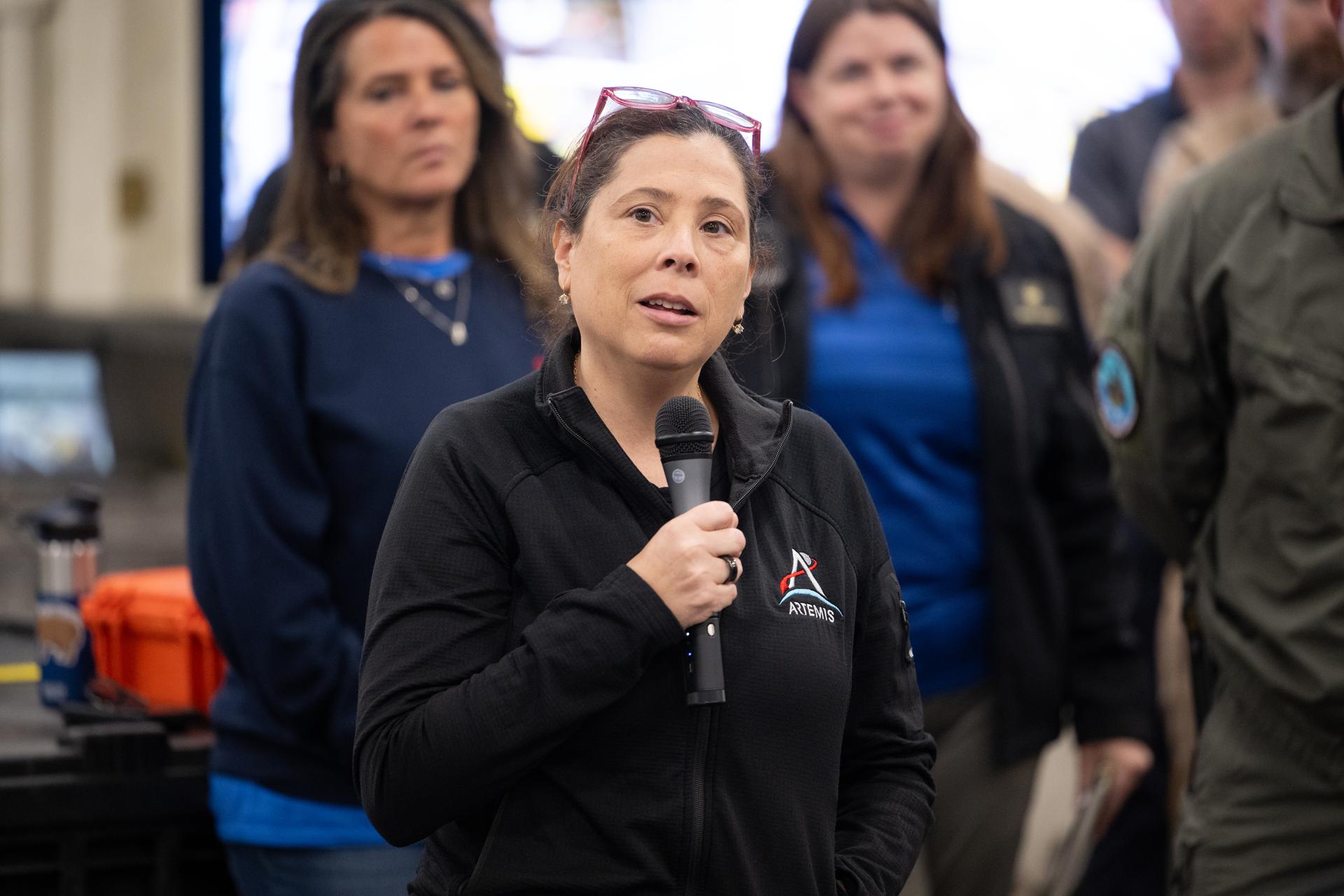 Lilian Villarreal, Artemis II landing and recovery director for Exploration Ground Systems at NASA's Kennedy Space Center,  speaks to NASA and U.S. military recovery team members onboard USS John P. Murtha as they prepare for the return of NASA’s Orion spacecraft with Artemis II crewmembers NASA astronauts Reid Wiseman, commander; Victor Glover, pilot; Christina Koch, mission specialist; and CSA (Canadian Space Agency) astronaut Jeremy Hansen, mission specialist aboard in the Pacific Ocean off the coast of California, Friday, April 10, 2026. NASA’s Artemis II mission took Wiseman, Glover, Koch, and Hansen on a nearly 10-day journey around the Moon and back to Earth. The quartet splashed down in the Pacific Ocean at 5:07 p.m. PDT (8:07 p.m. EDT). Photo Credit: (NASA/Joel Kowsky)