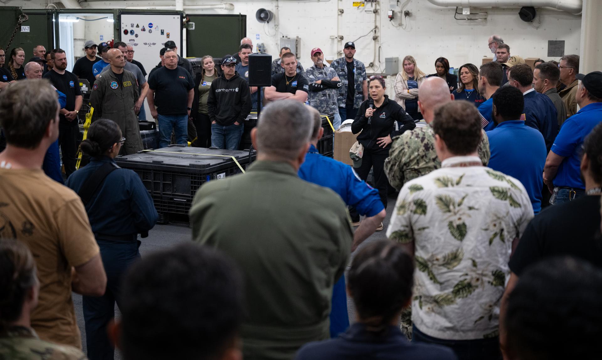 Lilian Villarreal, Artemis II landing and recovery director for Exploration Ground Systems at NASA's Kennedy Space Center,  speaks to NASA and U.S. military recovery team members onboard USS John P. Murtha as they prepare for the return of NASA’s Orion spacecraft with Artemis II crewmembers NASA astronauts Reid Wiseman, commander; Victor Glover, pilot; Christina Koch, mission specialist; and CSA (Canadian Space Agency) astronaut Jeremy Hansen, mission specialist aboard in the Pacific Ocean off the coast of California, Friday, April 10, 2026. NASA’s Artemis II mission took Wiseman, Glover, Koch, and Hansen on a nearly 10-day journey around the Moon and back to Earth. The quartet splashed down in the Pacific Ocean at 5:07 p.m. PDT (8:07 p.m. EDT). Photo Credit: (NASA/Joel Kowsky)