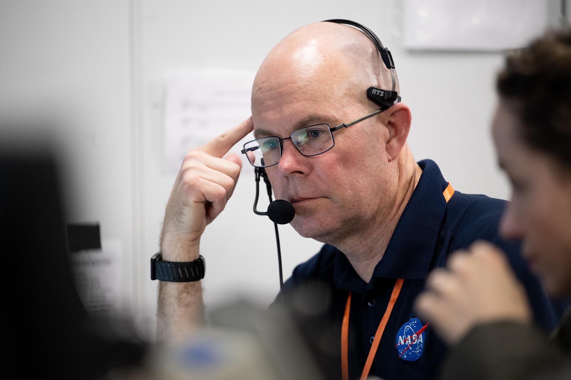 Dr. Benjamin Johansen, NASA flight surgeon, is seen alongside other NASA and U.S. military recovery team members as they work inside the Landing Force Operations Center onboard USS John P. Murtha monitoring the recovery of NASA’s Orion spacecraft with Artemis II crewmembers NASA astronauts Reid Wiseman, commander; Victor Glover, pilot; Christina Koch, mission specialist; and CSA (Canadian Space Agency) astronaut Jeremy Hansen, mission specialist aboard in the Pacific Ocean off the coast of California, Friday, April 10, 2026. NASA’s Artemis II mission took Wiseman, Glover, Koch, and Hansen on a 10-day journey around the Moon and back to Earth. Following a splashdown at 5:07 p.m. PDT (8:07 p.m. EDT), NASA and U.S. military teams worked to bring the crewmembers and Orion spacecraft aboard USS John P. Murtha.  Photo Credit: (NASA/Joel Kowsky)