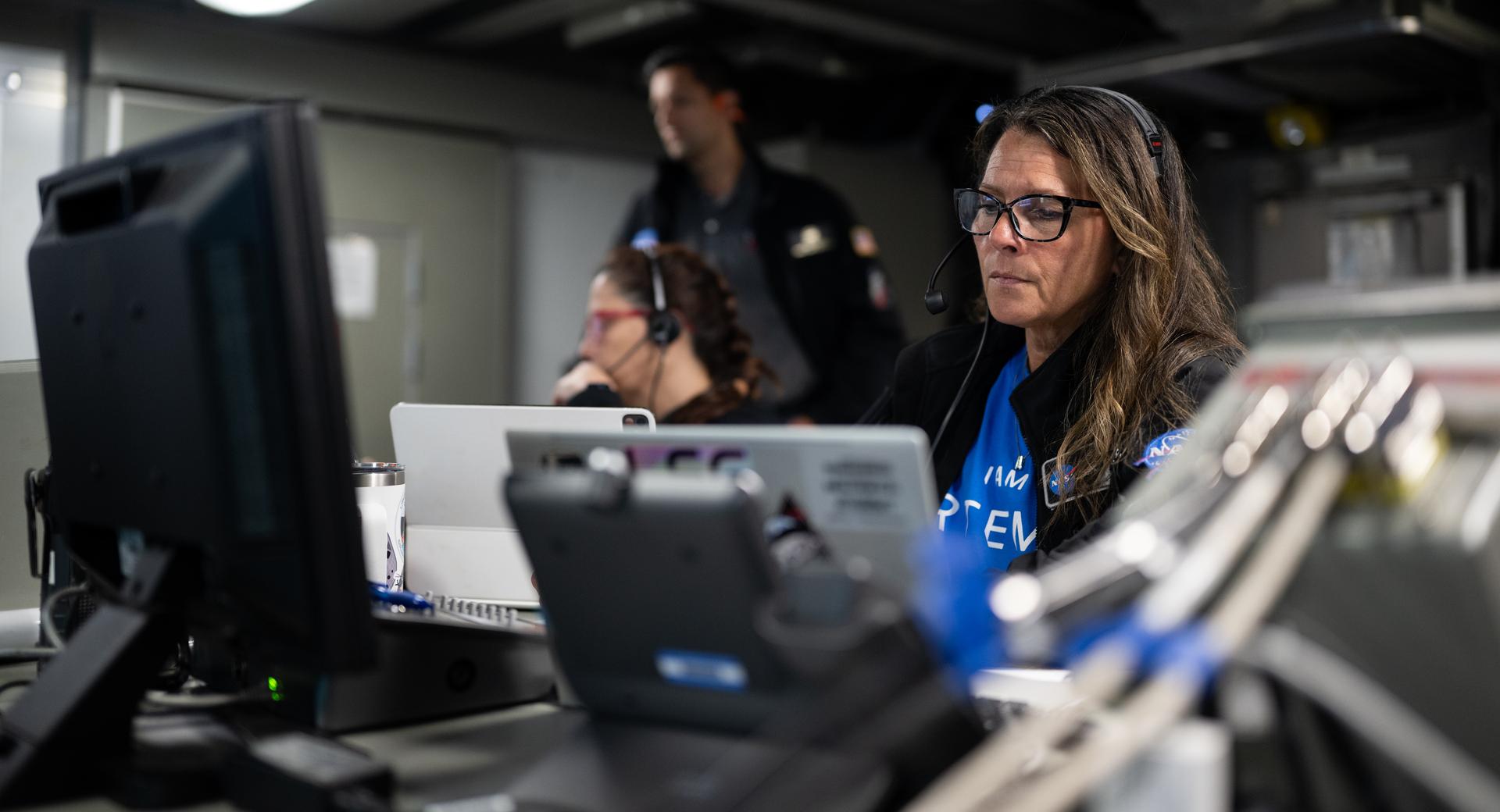 Lisa Seiler, Artemis II landing and recovery deputy director, is seen alongside other NASA and U.S. military recovery team members as they work inside the Landing Force Operations Center onboard USS John P. Murtha monitoring the recovery of NASA’s Orion spacecraft with Artemis II crewmembers NASA astronauts Reid Wiseman, commander; Victor Glover, pilot; Christina Koch, mission specialist; and CSA (Canadian Space Agency) astronaut Jeremy Hansen, mission specialist aboard in the Pacific Ocean off the coast of California, Friday, April 10, 2026. NASA’s Artemis II mission took Wiseman, Glover, Koch, and Hansen on a 10-day journey around the Moon and back to Earth. Following a splashdown at 5:07 p.m. PDT (8:07 p.m. EDT), NASA and U.S. military teams worked to bring the crewmembers and Orion spacecraft aboard USS John P. Murtha.  Photo Credit: (NASA/Joel Kowsky)