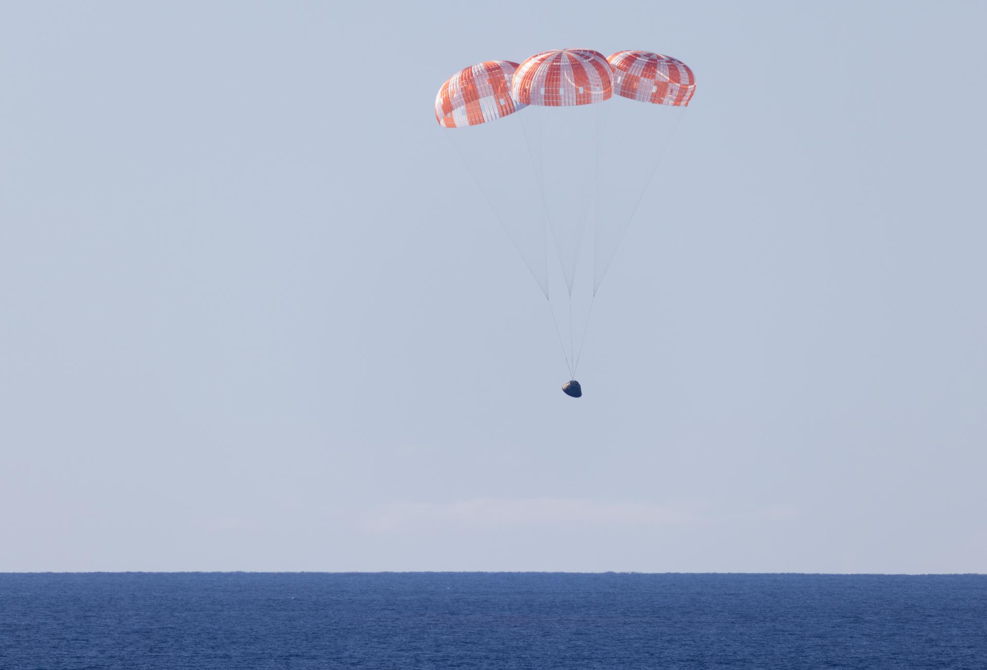NASA’s Orion spacecraft with Artemis II crewmembers NASA astronauts Reid Wiseman, commander; Victor Glover, pilot; Christina Koch, mission specialist; and CSA (Canadian Space Agency) astronaut Jeremy Hansen, mission specialist aboard is seen under parachutes as it lands in the Pacific Ocean off the coast of California, Friday, April 10, 2026. NASA’s Artemis II mission took Wiseman, Glover, Koch, and Hansen on a 10-day journey around the Moon and back to Earth. Following a splashdown at 8:07 p.m. EDT, NASA, U.S. Navy, and U.S. Air Force teams are working to bring the crewmembers and Orion spacecraft aboard USS John P. Murtha.  Photo Credit: (NASA/Joel Kowsky)