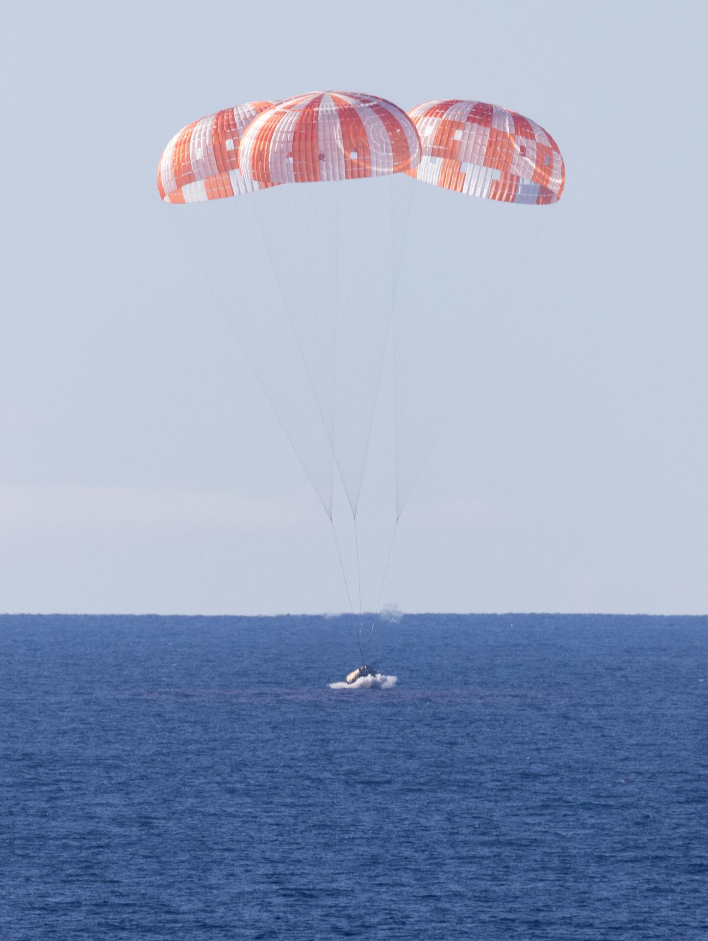 NASA’s Orion spacecraft with Artemis II crewmembers NASA astronauts Reid Wiseman, commander; Victor Glover, pilot; Christina Koch, mission specialist; and CSA (Canadian Space Agency) astronaut Jeremy Hansen, mission specialist aboard is seen as it lands in the Pacific Ocean off the coast of California, Friday, April 10, 2026. NASA’s Artemis II mission took Wiseman, Glover, Koch, and Hansen on a 10-day journey around the Moon and back to Earth. Following a splashdown at 8:07 p.m. EDT, NASA, U.S. Navy, and U.S. Air Force teams are working to bring the crewmembers and Orion spacecraft aboard USS John P. Murtha.  Photo Credit: (NASA/Joel Kowsky)
