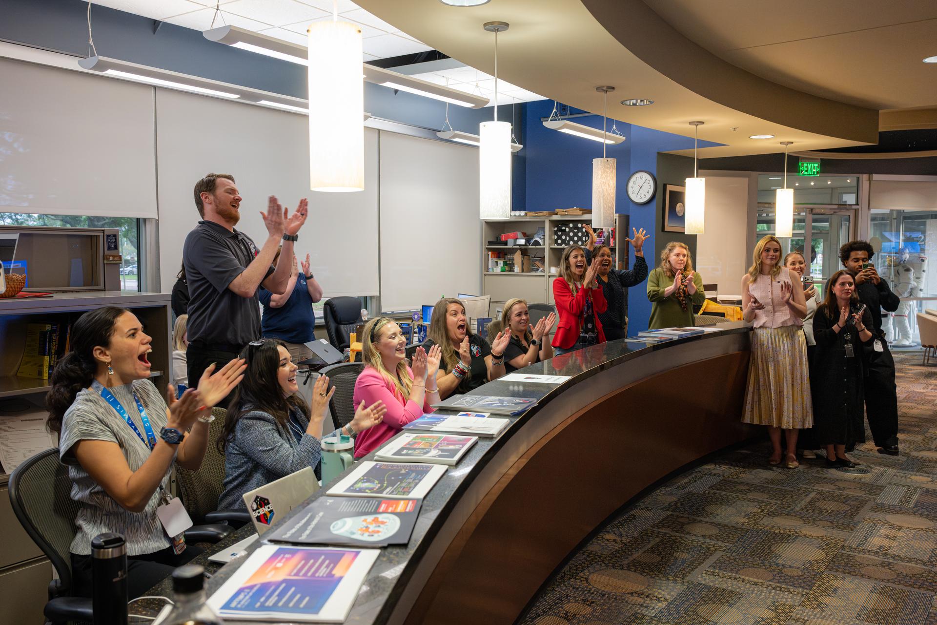 Members of NASA’s communications team react to the successful splashdown of the Orion spacecraft during the Artemis II mission, Friday, Apr. 10, 2026, at NASA’s Johnson Space Center in Houston, Texas. Photo Credit: (NASA/John Kraus)