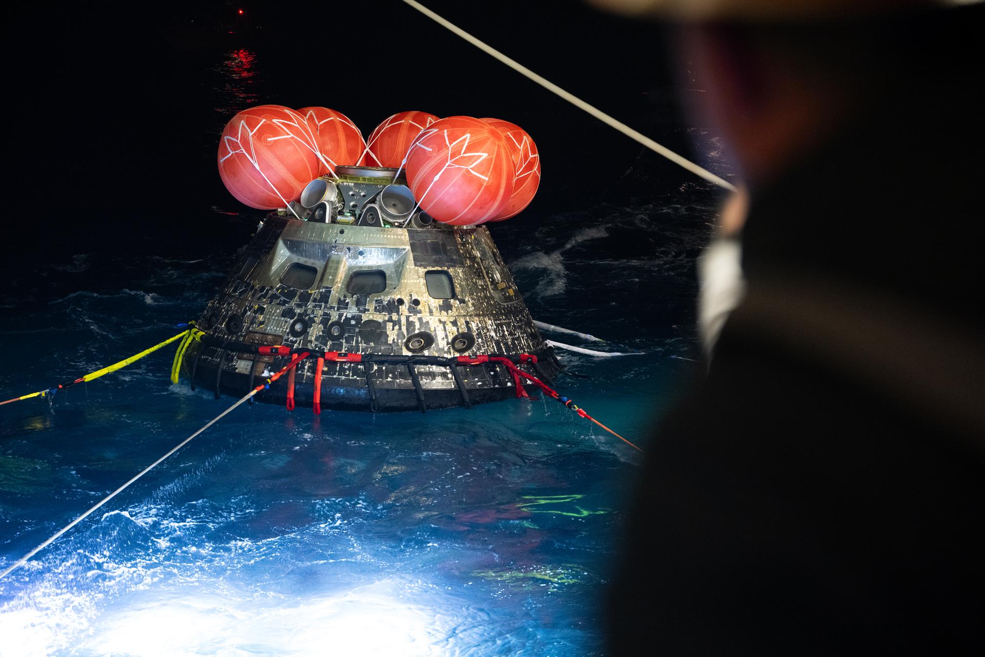 NASA’s Orion spacecraft is seen as the agency’s Landing and Recovery team, along with U.S. Navy personnel work to recover the spacecraft into the well deck of USS John P. Murtha in the Pacific Ocean off the coast of California, Saturday, April 11, 2026. NASA’s Artemis II mission, which took NASA astronauts Reid Wiseman, commander; Victor Glover, pilot; Christina Koch, mission specialist; and CSA (Canadian Space Agency) astronaut Jeremy Hansen, mission specialist on a nearly 10-day journey around the Moon and back to Earth, splashed down at 5:07 p.m. PDT (8:07 p.m. EDT).  Photo Credit: (NASA/Joel Kowsky)