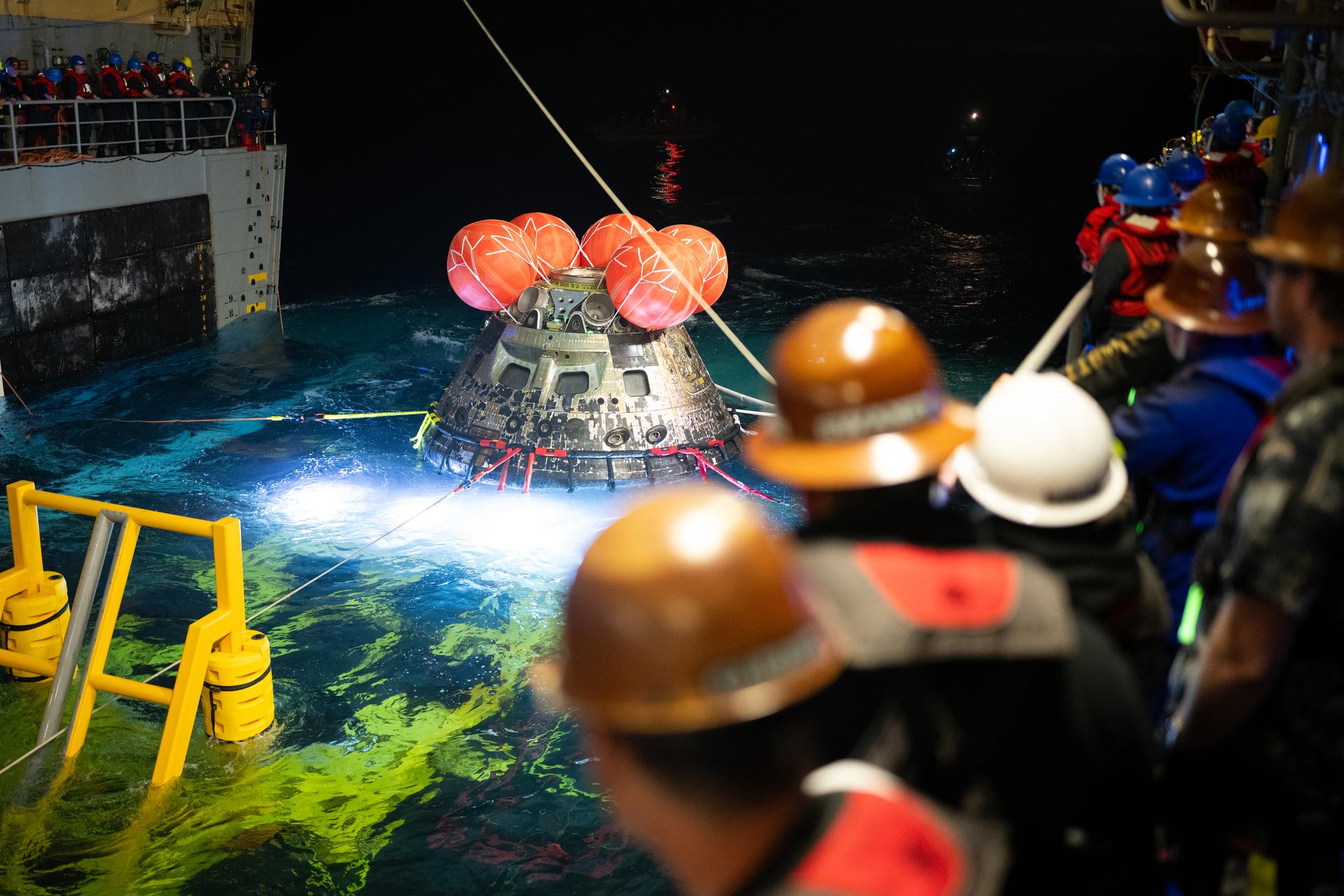 NASA’s Orion spacecraft is seen as the agency’s Landing and Recovery team, along with U.S. Navy personnel work to recover the spacecraft into the well deck of USS John P. Murtha in the Pacific Ocean off the coast of California, Saturday, April 11, 2026. NASA’s Artemis II mission, which took NASA astronauts Reid Wiseman, commander; Victor Glover, pilot; Christina Koch, mission specialist; and CSA (Canadian Space Agency) astronaut Jeremy Hansen, mission specialist on a nearly 10-day journey around the Moon and back to Earth, splashed down at 5:07 p.m. PDT (8:07 p.m. EDT).  Photo Credit: (NASA/Joel Kowsky)