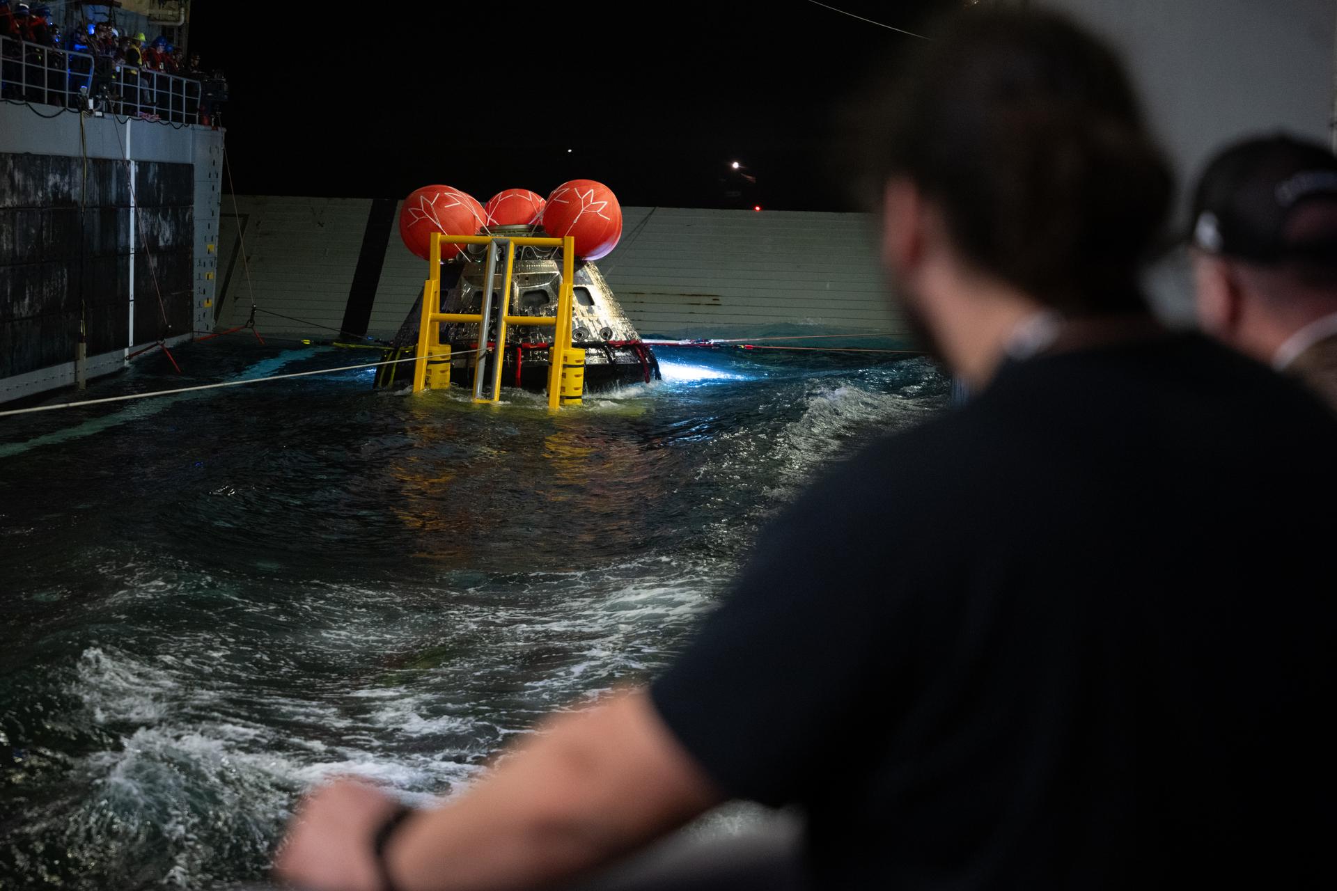 NASA’s Orion spacecraft is seen as the agency’s Landing and Recovery team, along with U.S. Navy personnel work to recover the spacecraft into the well deck of USS John P. Murtha in the Pacific Ocean off the coast of California, Saturday, April 11, 2026. NASA’s Artemis II mission, which took NASA astronauts Reid Wiseman, commander; Victor Glover, pilot; Christina Koch, mission specialist; and CSA (Canadian Space Agency) astronaut Jeremy Hansen, mission specialist on a nearly 10-day journey around the Moon and back to Earth, splashed down at 5:07 p.m. PDT (8:07 p.m. EDT).  Photo Credit: (NASA/Joel Kowsky)