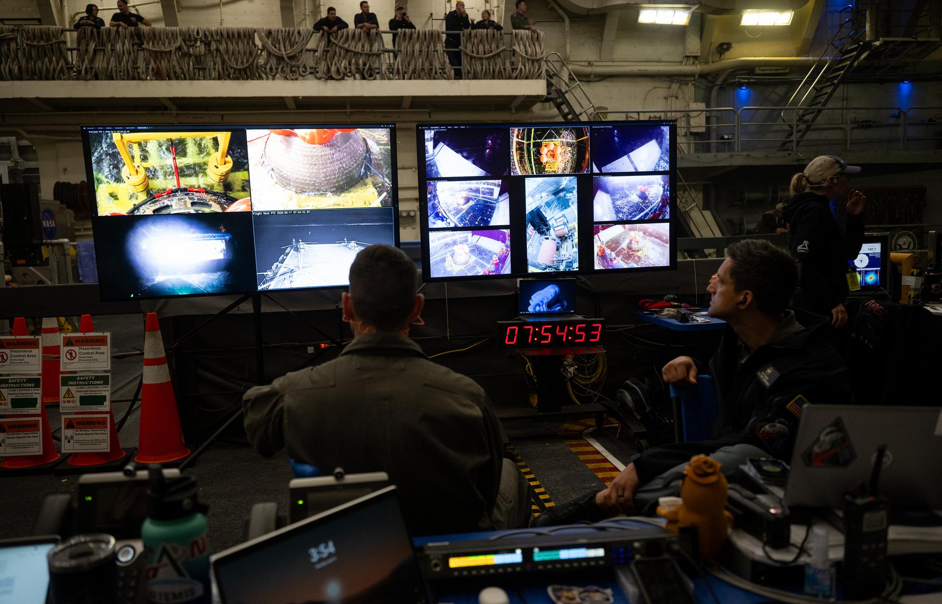 NASA’s Landing and Recovery team monitors the progress of recovering the agency’s Orion spacecraft as they work along with U.S. Navy personnel to bring the spacecraft into the well deck of USS John P. Murtha in the Pacific Ocean off the coast of California, Saturday, April 11, 2026. NASA’s Artemis II mission, which took NASA astronauts Reid Wiseman, commander; Victor Glover, pilot; Christina Koch, mission specialist; and CSA (Canadian Space Agency) astronaut Jeremy Hansen, mission specialist on a nearly 10-day journey around the Moon and back to Earth, splashed down at 5:07 p.m. PDT (8:07 p.m. EDT).  Photo Credit: (NASA/Joel Kowsky)