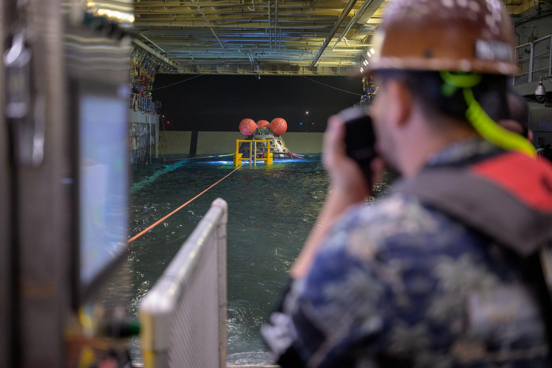 NASA’s Orion spacecraft is seen as the agency’s Landing and Recovery team, along with U.S. Navy personnel work to recover the spacecraft into the well deck of USS John P. Murtha in the Pacific Ocean off the coast of California, Saturday, April 11, 2026. NASA’s Artemis II mission, which took NASA astronauts Reid Wiseman, commander; Victor Glover, pilot; Christina Koch, mission specialist; and CSA (Canadian Space Agency) astronaut Jeremy Hansen, mission specialist on a 10-day journey around the Moon and back to Earth, splashed down at at 5:07 p.m. PDT (8:07 p.m. EDT).  Photo Credit: (NASA/Bill Ingalls)