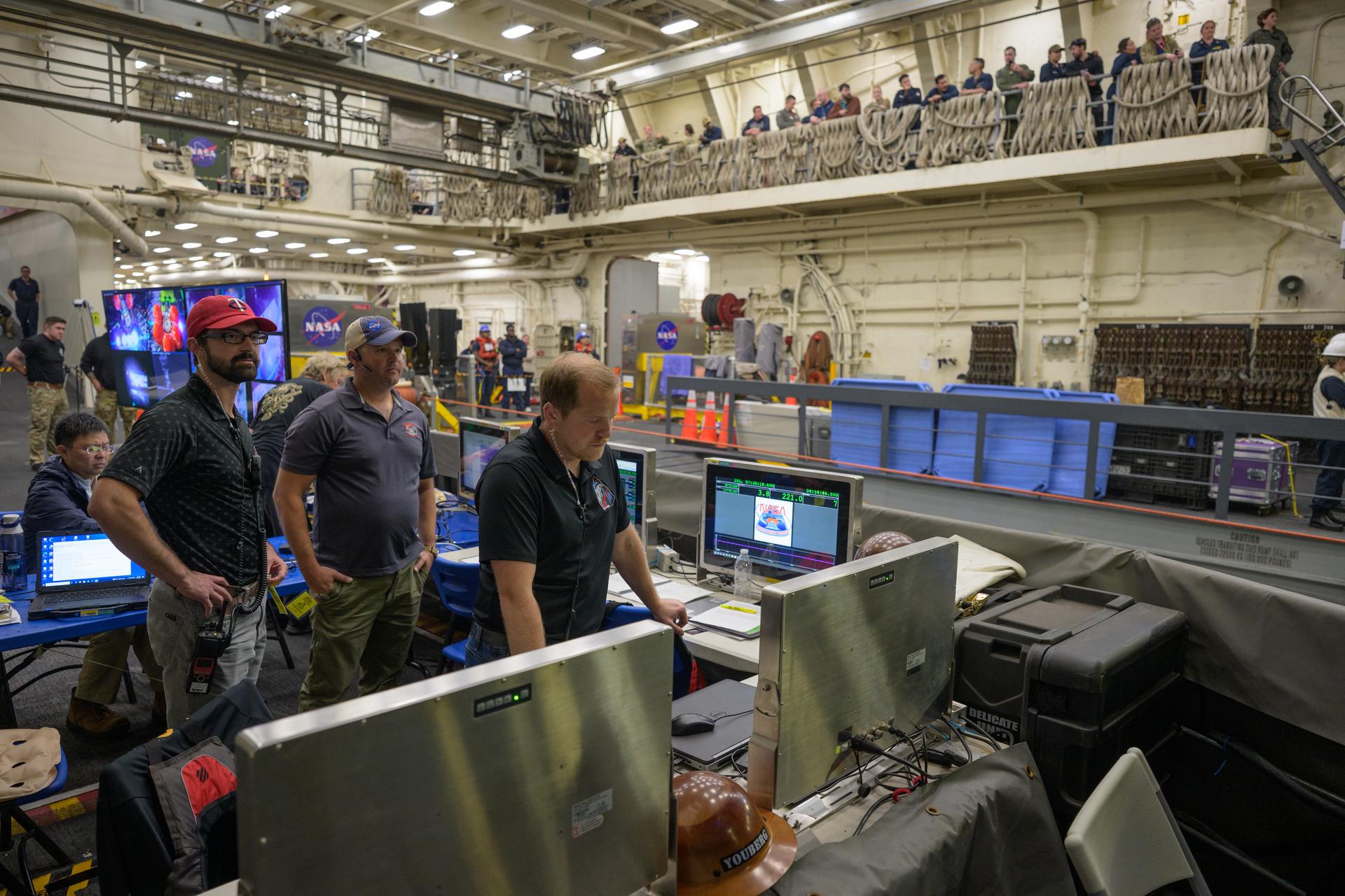 NASA’s Landing and Recovery team, along with U.S. Navy personnel work to recover the spacecraft into the well deck of USS John P. Murtha in the Pacific Ocean off the coast of California, Saturday, April 11, 2026. NASA’s Artemis II mission, which took NASA astronauts Reid Wiseman, commander; Victor Glover, pilot; Christina Koch, mission specialist; and CSA (Canadian Space Agency) astronaut Jeremy Hansen, mission specialist on a 10-day journey around the Moon and back to Earth, splashed down at at 5:07 p.m. PDT (8:07 p.m. EDT).  Photo Credit: (NASA/Bill Ingalls)