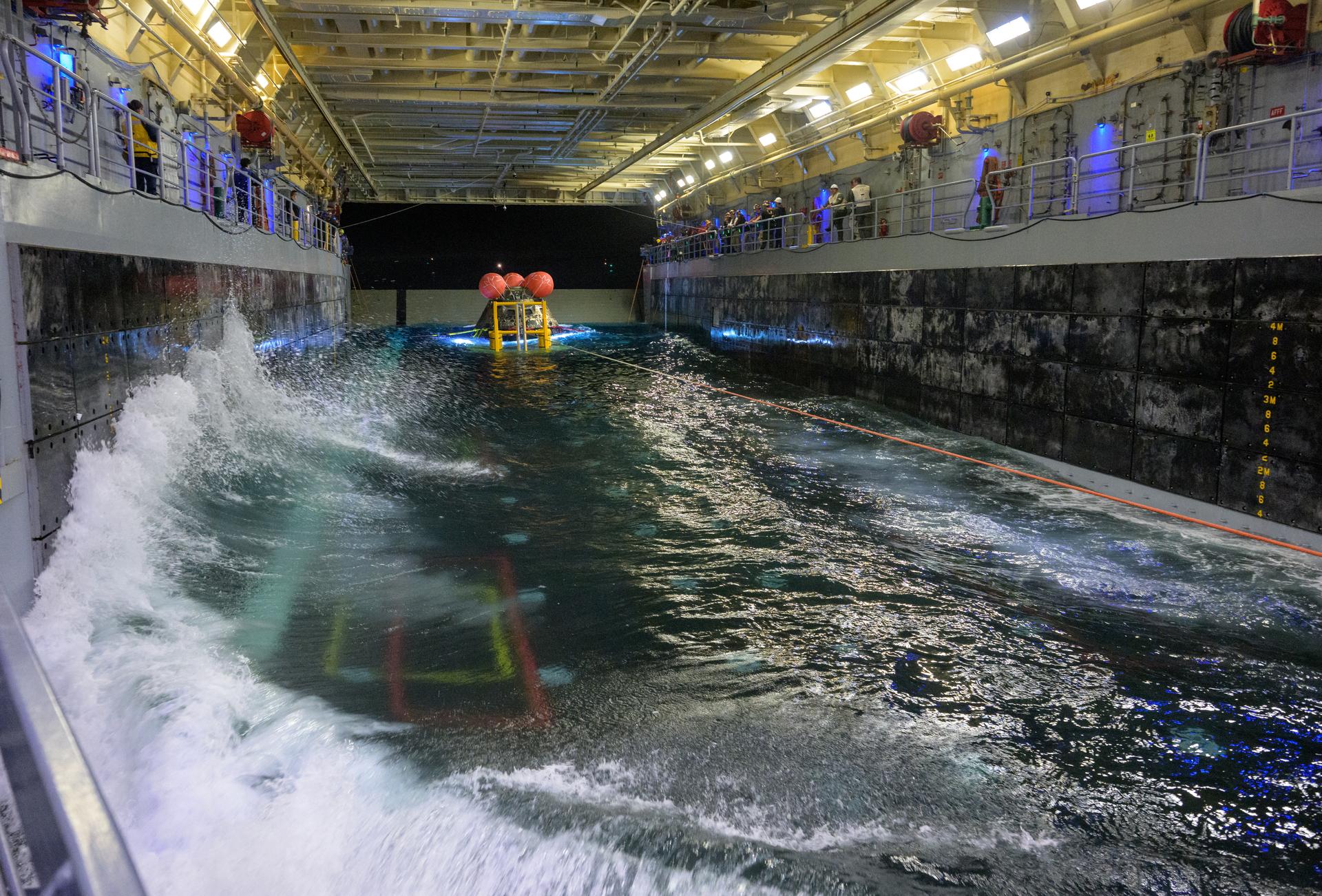 NASA’s Orion spacecraft is seen as the agency’s Landing and Recovery team, along with U.S. Navy personnel work to securethe spacecraft into the well deck of USS John P. Murtha in the Pacific Ocean off the coast of California, Saturday, April 11, 2026. NASA’s Artemis II mission, which took NASA astronauts Reid Wiseman, commander; Victor Glover, pilot; Christina Koch, mission specialist; and CSA (Canadian Space Agency) astronaut Jeremy Hansen, mission specialist on a 10-day journey around the Moon and back to Earth, splashed down at ,  Photo Credit: (NASA/Bill Ingalls)
