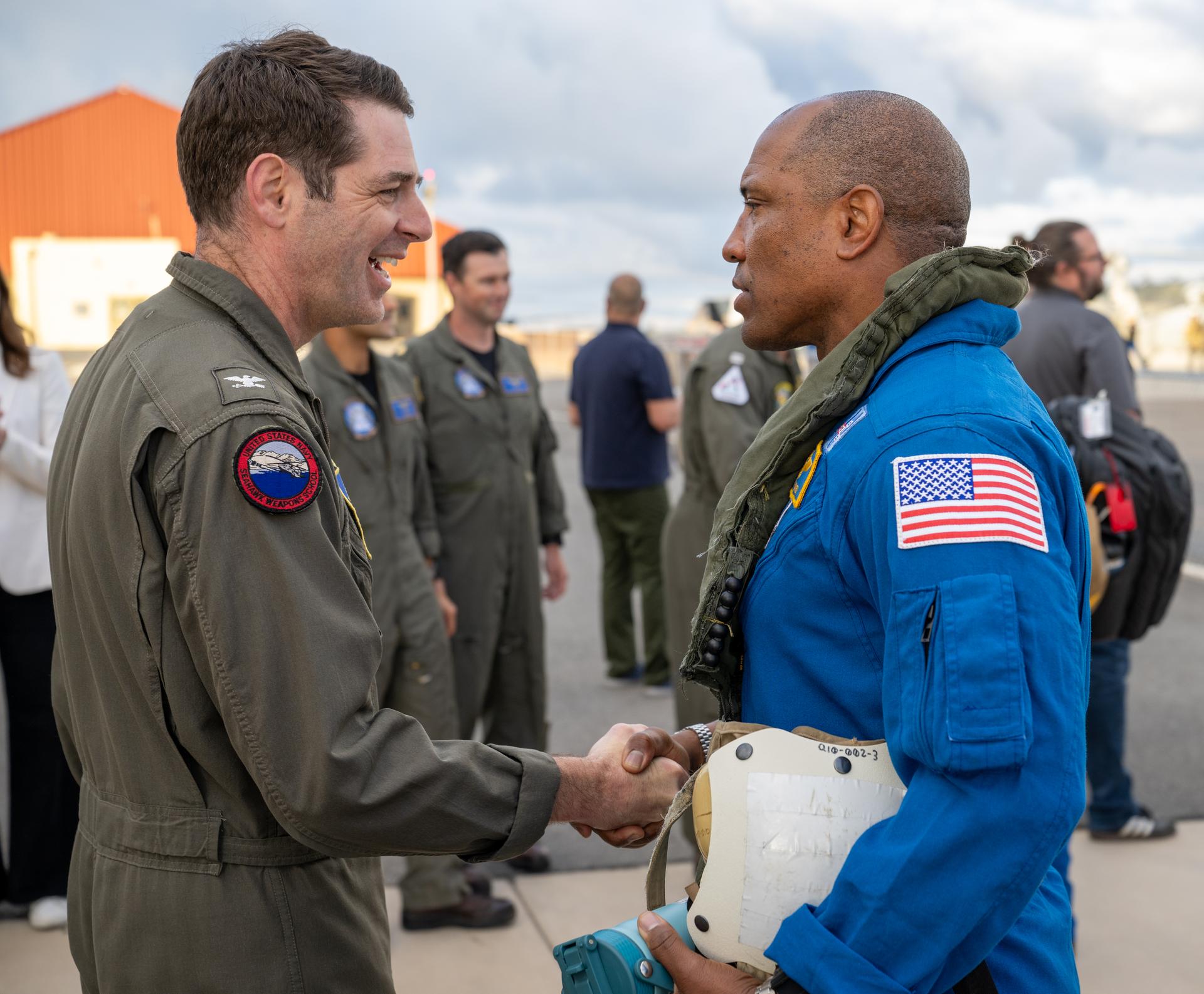 Artemis II NASA astronaut Victor Glover, pilot,  greets Capt. Loren “Wookie” Jacobi of Naval Base San Diego after being flown from USS John P. Murtha to Naval Air Station North Island on Navy MH-60 Seahawks from Helicopter Sea Combat Squadron (HSC) 23, Saturday, April 11, 2026, following a splashdown in the Pacific Ocean off the coast of California at 5:07 p.m. PDT (8:07 p.m. EDT) on April 10. NASA’s Artemis II mission took NASA astronauts Reid Wiseman, commander; Victor Glover, pilot; Christina Koch, mission specialist; and CSA (Canadian Space Agency) astronaut Jeremy Hansen, mission specialist on a nearly ten day journey around the Moon and back to Earth. Photo Credit: (NASA/Keegan Barber)