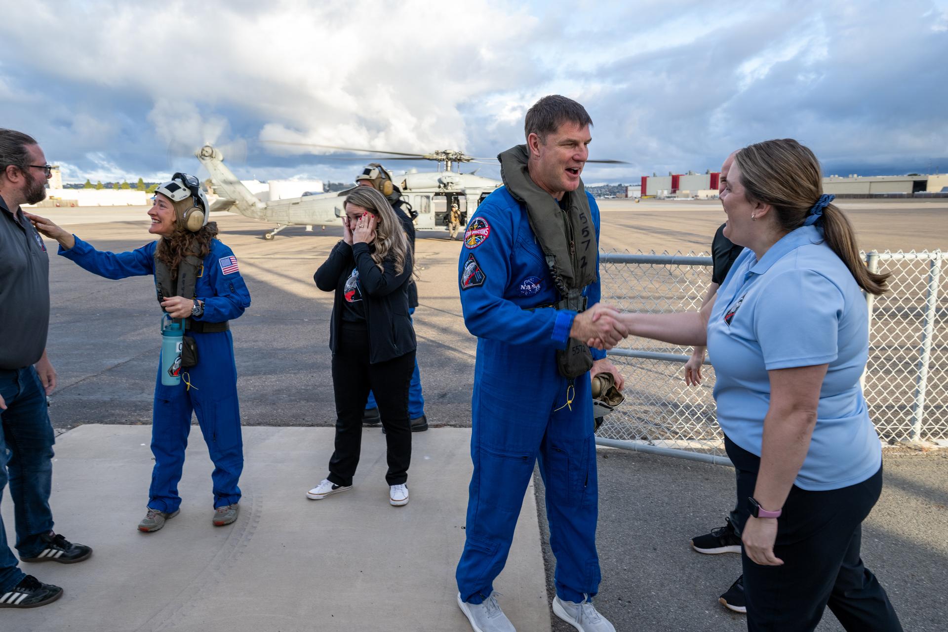 Artemis II NASA astronaut Christina Koch, mission specialist, and CSA (Canadian Space Agency) astronaut Jeremy Hansen, greet NASA team members after being flown from USS John P. Murtha to Naval Air Station North Island on Navy MH-60 Seahawks from Helicopter Sea Combat Squadron (HSC) 23, Saturday, April 11, 2026, following a splashdown in the Pacific Ocean off the coast of California at 5:07 p.m. PDT (8:07 p.m. EDT) on April 10. NASA’s Artemis II mission took NASA astronauts Reid Wiseman, commander; Victor Glover, pilot; Christina Koch, mission specialist; and CSA (Canadian Space Agency) astronaut Jeremy Hansen, mission specialist on a nearly ten day journey around the Moon and back to Earth. Photo Credit: (NASA/Keegan Barber)