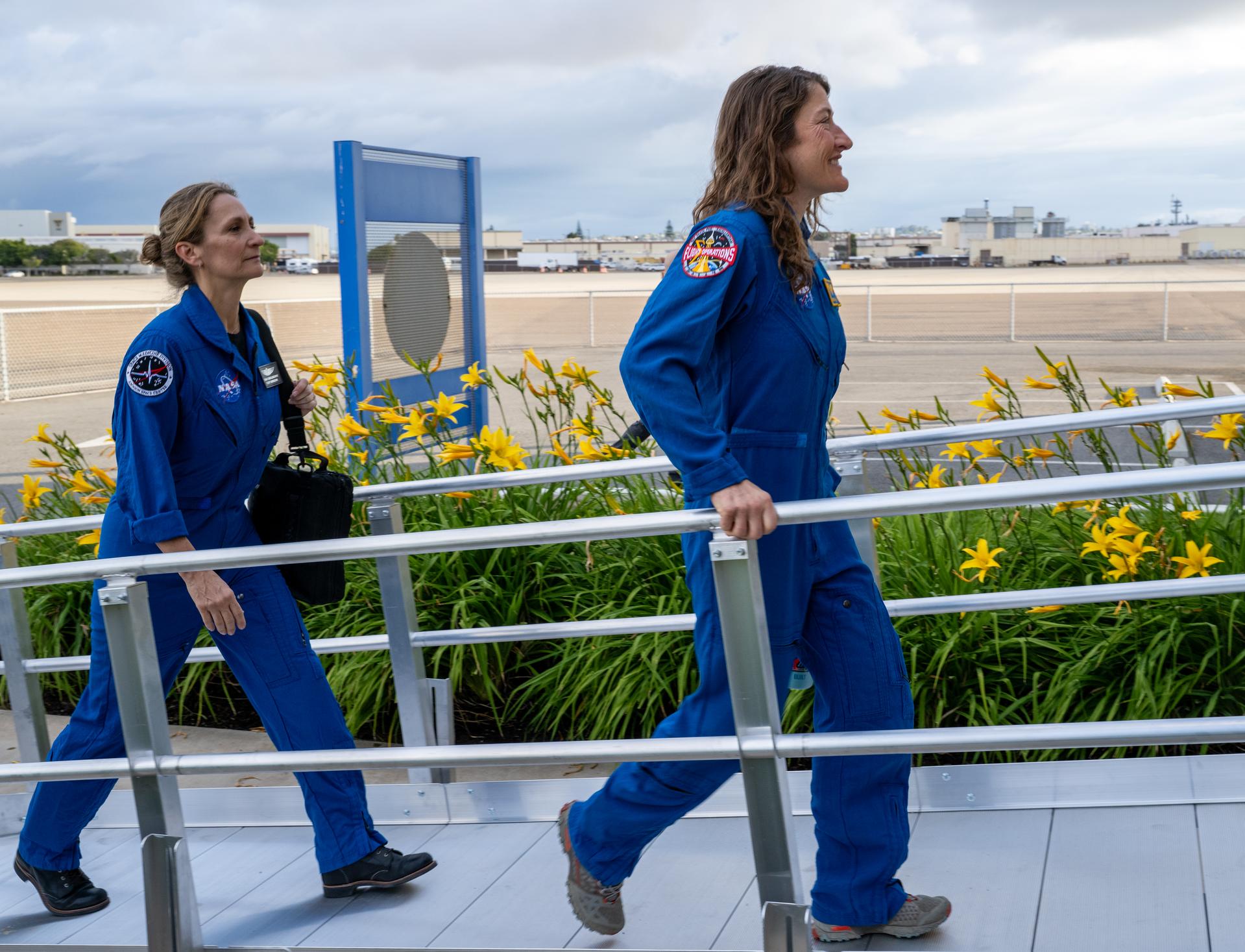 Artemis II NASA astronaut Christina Koch, mission specialist, right, joined by Tarah Castleberry, flight surgeon, left, is seen after being flown from USS John P. Murtha to Naval Air Station North Island on Navy MH-60 Seahawks from Helicopter Sea Combat Squadron (HSC) 23, Saturday, April 11, 2026, following a splashdown in the Pacific Ocean off the coast of California at 5:07 p.m. PDT (8:07 p.m. EDT) on April 10. NASA’s Artemis II mission took NASA astronauts Reid Wiseman, commander; Victor Glover, pilot; Christina Koch, mission specialist; and CSA (Canadian Space Agency) astronaut Jeremy Hansen, mission specialist on a nearly ten day journey around the Moon and back to Earth. Photo Credit: (NASA/Keegan Barber)