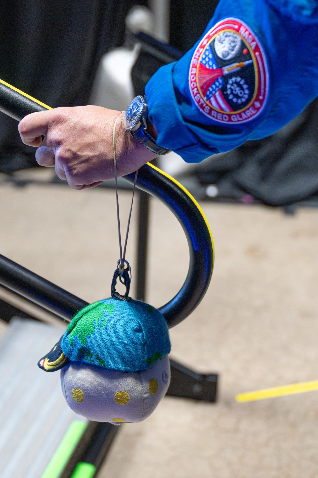 The Artemis II zero gravity indicator, "Rise," is seen looped around the wrist of NASA astronaut Reid Wiseman, Artemis II commander, before the Artemis II crew appeared on stage for a crew return event, Saturday, Apr. 11, 2026, at Ellington Field in Houston, Texas. NASA’s Artemis II test flight took Commander Reid Wiseman, Pilot Victor Glover, and Mission Specialist Christina Koch from NASA, and Mission Specialist Jeremy Hansen from the CSA (Canadian Space Agency) on an approximately nine-day mission around the Moon and back to Earth. Photo Credit: (NASA/John Kraus)