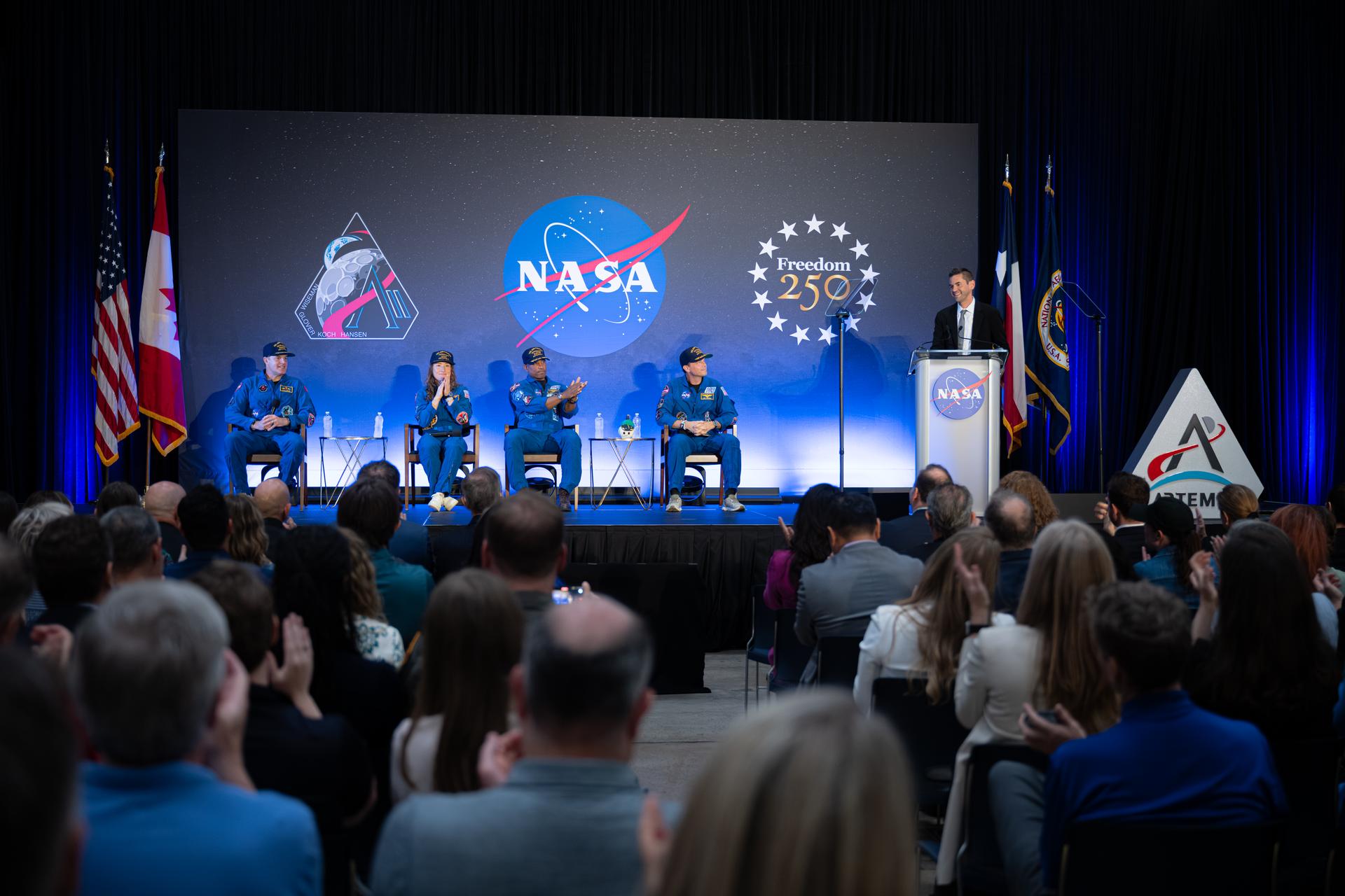 NASA Administrator Jared Isaacman, right, speaks as the Artemis II crew of Mission Specialist Jeremy Hansen from the CSA (Canadian Space Agency) and Mission Specialist Christina Koch, Pilot Victor Glover, and Commander Reid Wiseman from NASA listen, during a crew return event, Saturday, Apr. 11, 2026, at Ellington Field in Houston, Texas. NASA’s Artemis II test flight took Commander Reid Wiseman, Pilot Victor Glover, and Mission Specialist Christina Koch from NASA, and Mission Specialist Jeremy Hansen from the CSA (Canadian Space Agency) on an approximately nine-day mission around the Moon and back to Earth. Photo Credit: (NASA/John Kraus)
