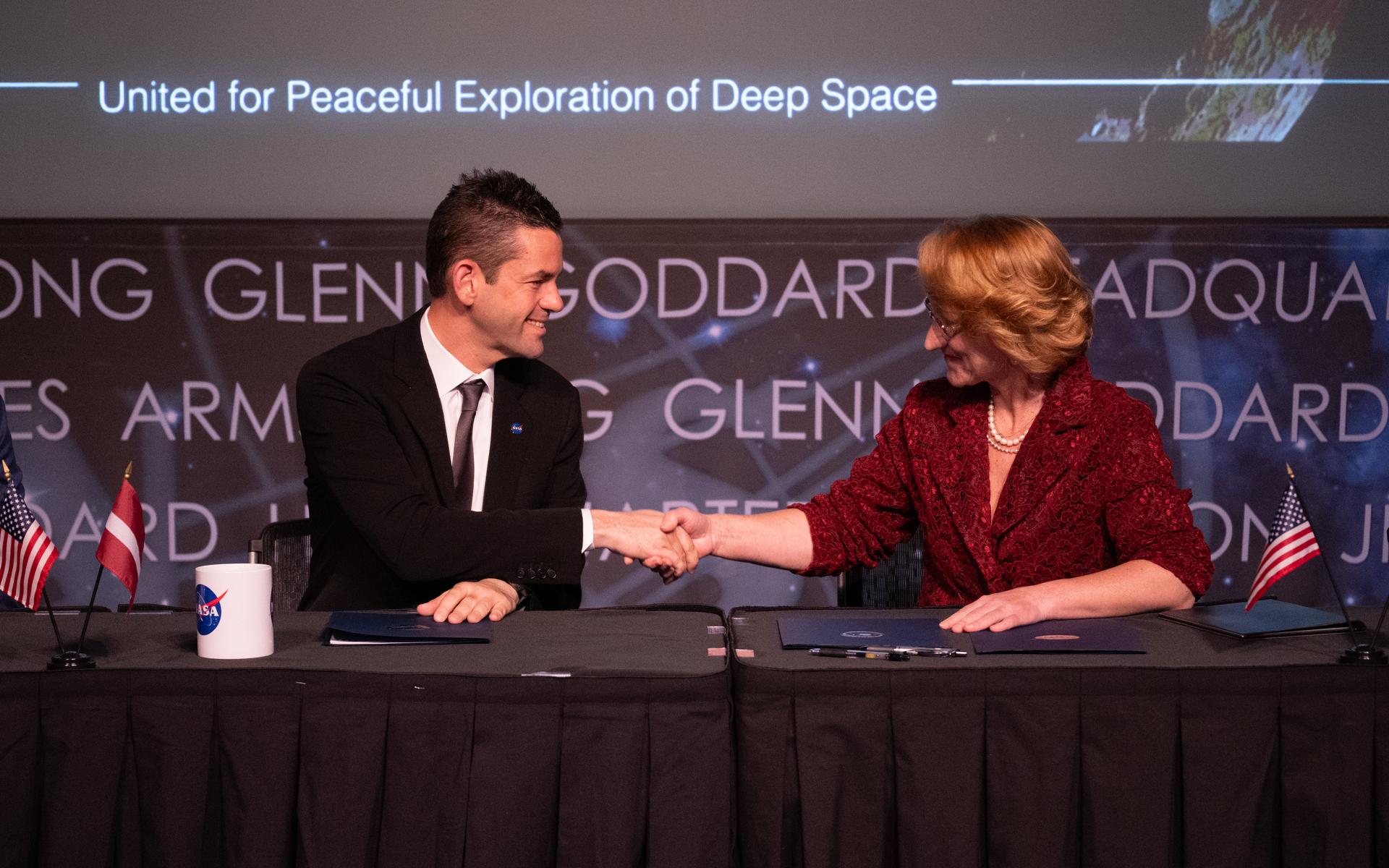NASA Administrator Jared Isaacman left, shakes hands with Dace Melbārde, Latvia’s Minister for Education and Science, following a signing of the Artemis Accords, Monday, April 20, 2026, at the Mary W. Jackson NASA Headquarters building in Washington. The Republic of Latvia is the 62nd country to sign the Artemis Accords, which establish a practical set of principles to guide space exploration cooperation among nations participating in NASA’s Artemis program.  Photo Credit: (NASA/Joel Kowsky)
