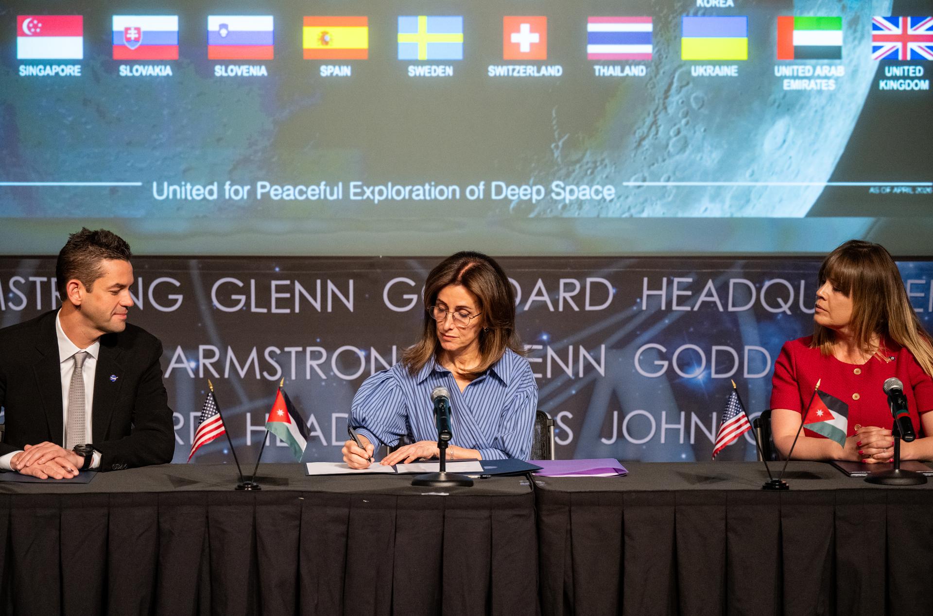 Ambassador of Jordan to the United States Dina Kawar, center, signs the Artemis Accords alongside NASA Administrator Jared Isaacman, left, and Acting Principal Deputy Assistant Secretary of State for Oceans and International Environmental and Scientific Affairs Ruth Perry, right, Thursday, April 23, 2026, at the Mary W. Jackson NASA Headquarters building in Washington. The Hashemite Kingdom of Jordan is the 63rd country to sign the Artemis Accords, which establish a practical set of principles to guide space exploration cooperation among nations participating in NASA’s Artemis program. Photo Credit: (NASA/Keegan Barber)
