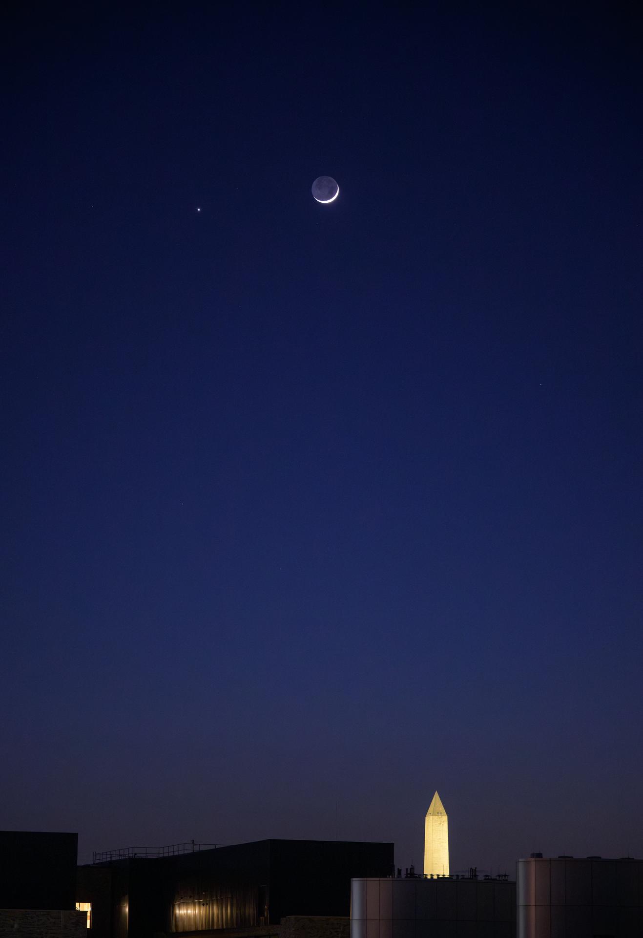 The Moon and Venus, left, are seen in conjunction above the Washington Monument, Monday, May 18, 2026, as viewed from the Mary W. Jackson NASA Headquarters Building in Washington. Photo Credit: (NASA/Bill Ingalls)