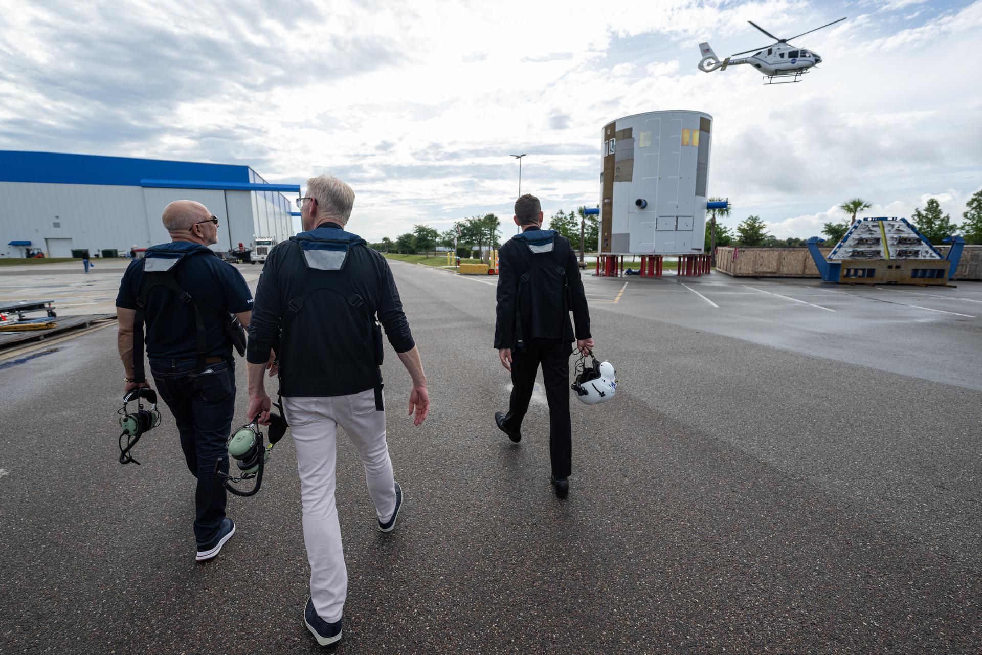 NASA Administrator Jared Isaacman, right; Jeff Bezos, founder, Blue Origin, left; and Dave Limp, chief executive officer, Blue Origin, center, are seen ahead of a helicopter flight, Friday, May 29, 2026, at Blue Origin’s Rocket Park in Merritt Island, Fla. The flight surveyed nearby Launch Complex 36 at Cape Canaveral Space Force Station following a New Glenn hotfire test anomaly on May 28. Photo Credit: (NASA/John Kraus)