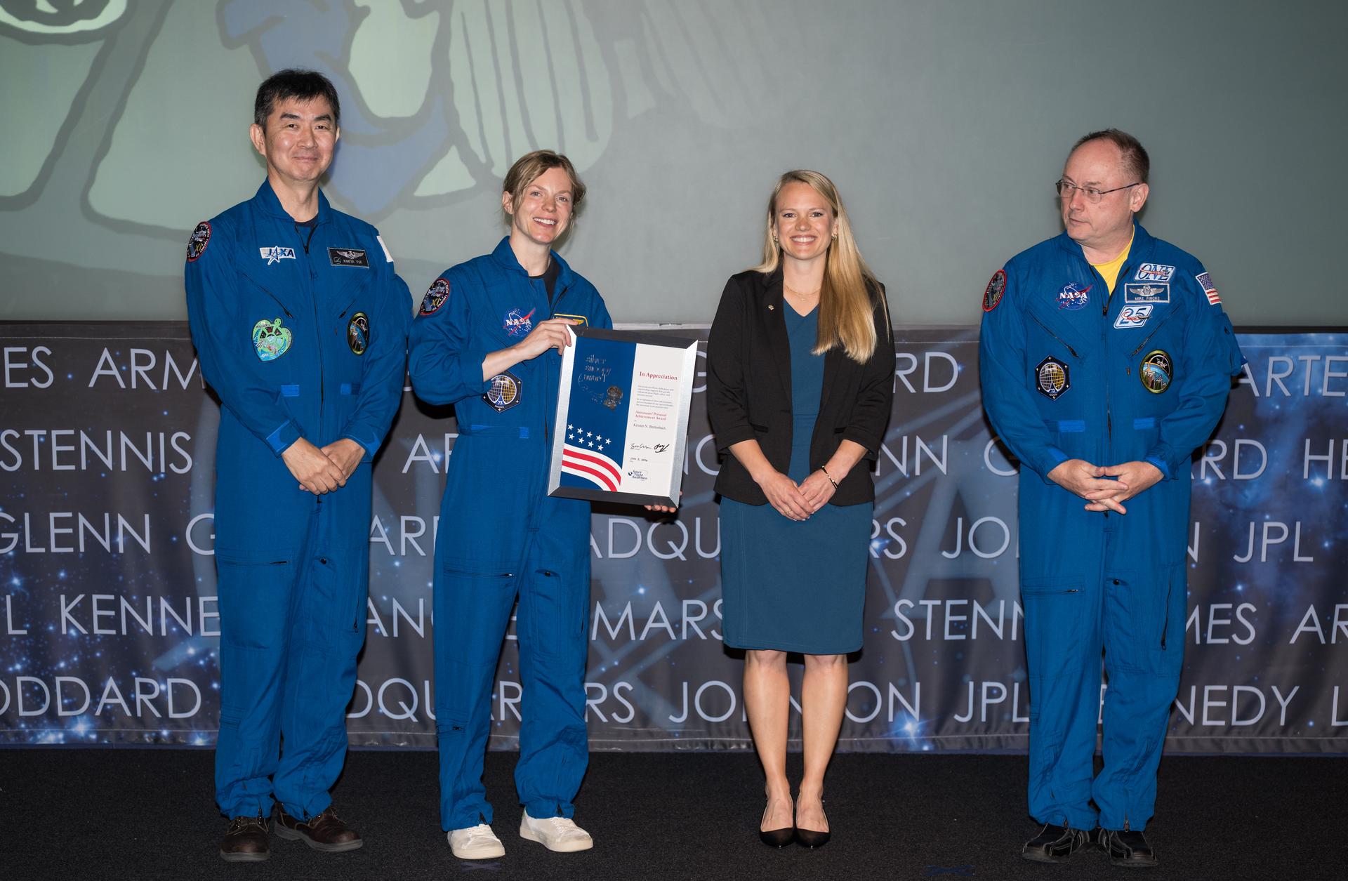 NASA astronauts Mike Fincke, Zena Cardman, and JAXA (Japan Aerospace Exploration Agency) astronaut Kimiya Yui, present Kristen Breitenbach with a Silver Snoopy award, Tuesday, June 2, 2026, at the Mary W. Jackson NASA Headquarters building in Washington. Fincke, Cardman, and Yui served as part of Expeditions 73 and 74 onboard the International Space Station. Photo Credit: (NASA/Aubrey Gemignani)