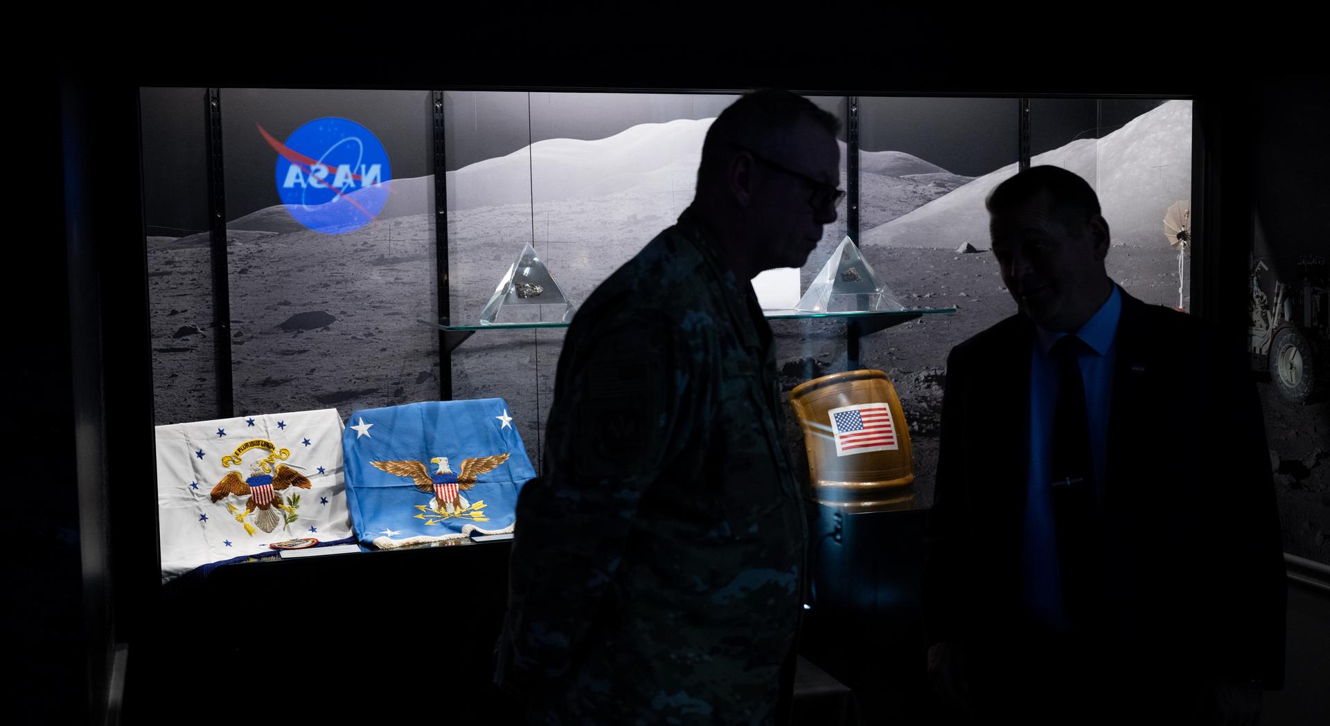 NASA Deputy Administrator Matt Anderson, right, and U.S. Air Force Lt. Gen. Luke Ahmann, Commander, Continental U.S. North American Aerospace Defense Command Region; Commander, 1st Air Force, speak in front of a display of lunar samples collected during the Apollo 17 mission and U.S. Vice Presidential and Secretary of Defense flags flown to space during the Apollo-Soyuz Test Mission, Tuesday, June 30, 2026, at the Mary W. Jackson NASA Headquarters building in Washington.  Photo Credit: (NASA/Joel Kowsky)