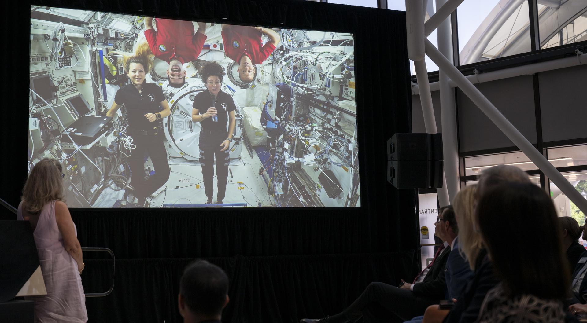 Guests watch a prerecorded message from members of Expedition 74 aboard the International Space Station during the Smithsonian’s National Air and Space Museum rededication ceremony Wednesday, July 1, 2026, in Washington. Photo Credit: (NASA/Keegan Barber)
