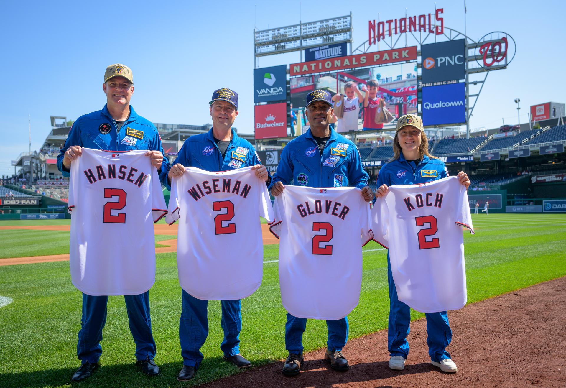 Artemis II astronauts; CSA (Canadian Space Agency) astronaut Jeremy Hansen, mission specialist, left, NASA astronauts Reid Wiseman, commander; Victor Glover, pilot; and Christina Koch, mission specialist, right, pose for a photograph with Nationals jerseys before the start of a baseball game between the Pittsburgh Pirates and the Washington Nationals, Saturday, July 4, 2026, at Nationals Park in Washington. NASA’s Artemis II mission took Wiseman, Glover, Koch, and Hansen on a nearly 10-day journey around the Moon and back to Earth in April 2026. Photo Credit: (NASA/Bill Ingalls)