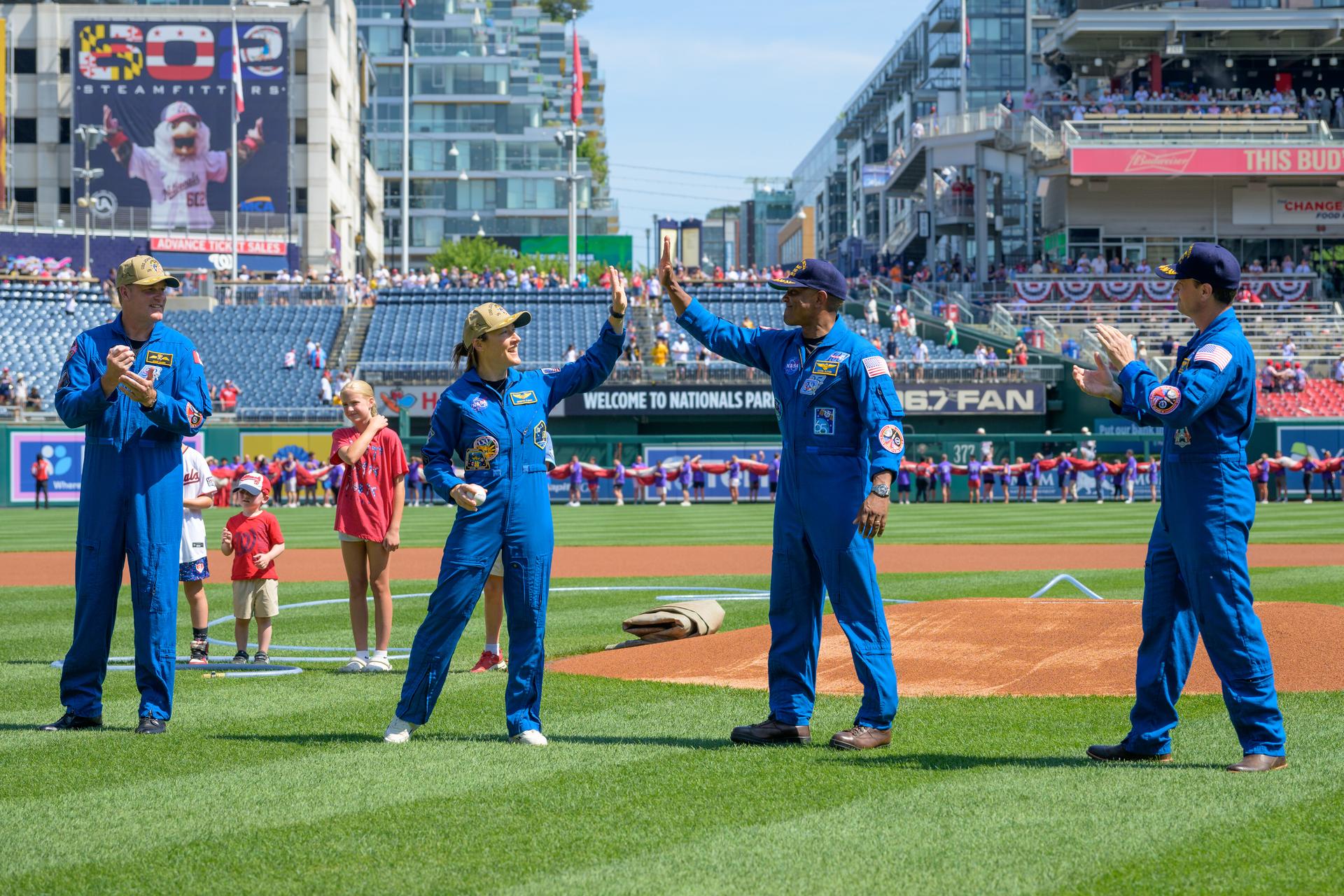 Artemis II astronauts: CSA (Canadian Space Agency) astronaut Jeremy Hansen, mission specialist, left, NASA astronauts Christina Koch, mission specialist; Victor Glover, pilot; and Reid Wiseman, commander, right, celebrate as they throw the ceremonial first pitches before the start of a baseball game between the Pittsburgh Pirates and the Washington Nationals, Saturday, July 4, 2026, at Nationals Park in Washington. NASA’s Artemis II mission took Wiseman, Glover, Koch, and Hansen on a nearly 10-day journey around the Moon and back to Earth in April 2026. Photo Credit: (NASA/Bill Ingalls)