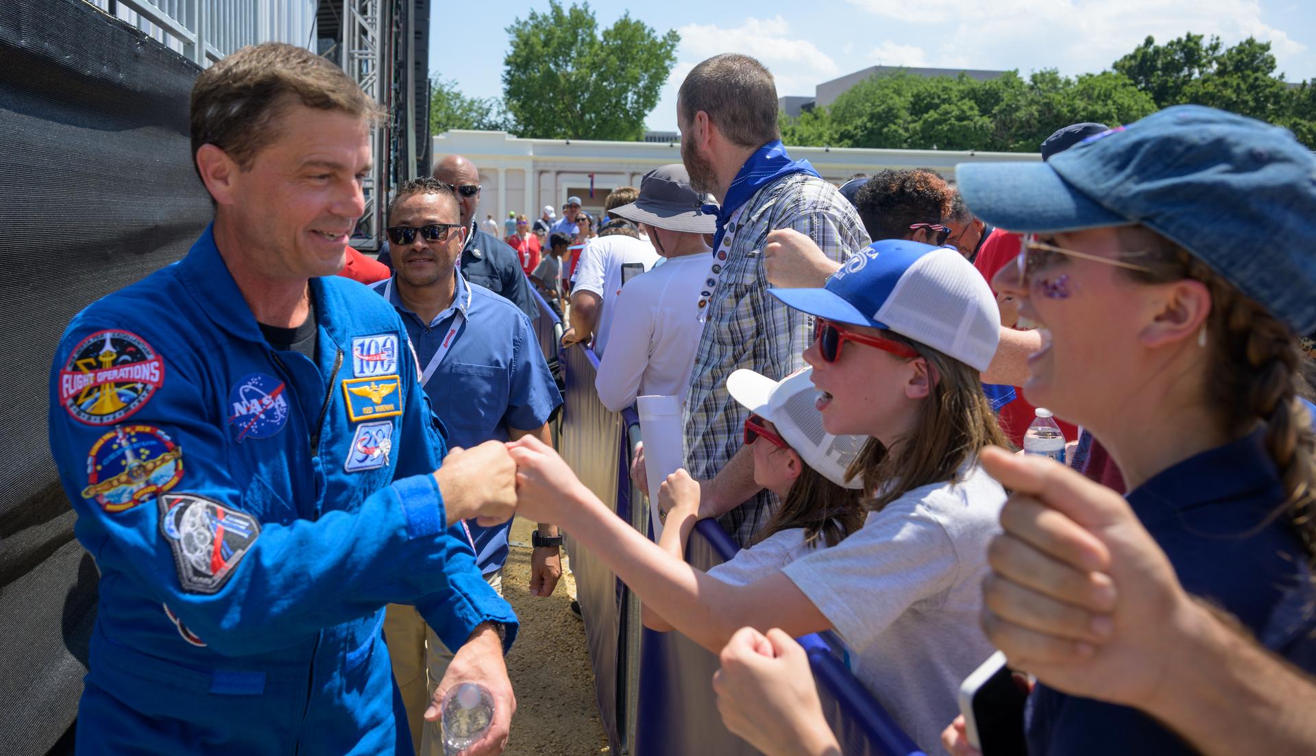 NASA astronaut Reid Wiseman, Artemis II commander, fist bumps an audience member after participating in a panel discussion during the Great American State Fair, Saturday, July 4, 2026, on the National Mall in Washington, D.C.  Photo Credit: (NASA/Bill Ingalls)