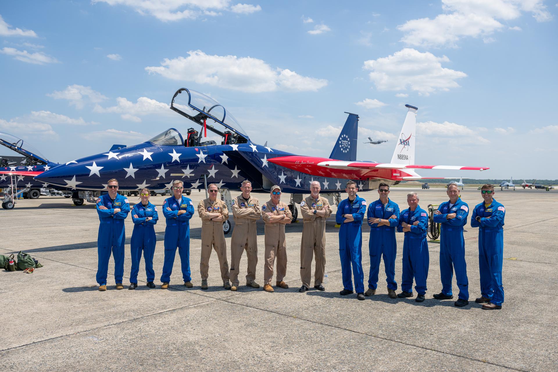 NASA Administrator Jared Isaacman, eighth from left, poses for a group photo with pilots and participants in NASA’s flyovers during the Great American State Fair, Saturday, July 4, 2026, at Joint Base Andrews in Prince George's County, Maryland. NASA aircraft conducted flyovers during the fair in Washington, D.C. Photo Credit: (NASA/John Kraus)