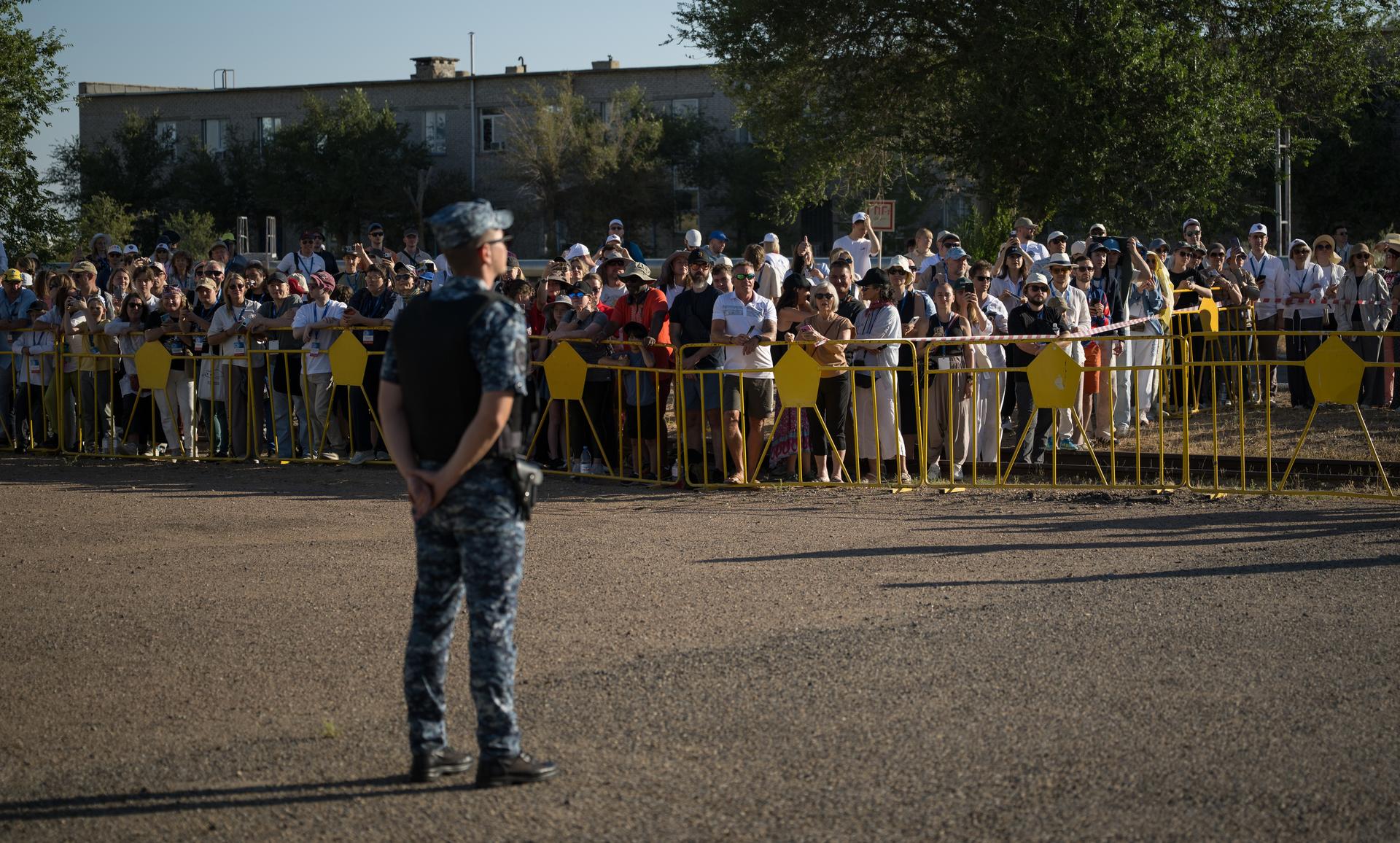 Crowds watch as the Soyuz rocket is rolled out by train to the launch pad, Saturday, July 11, 2026, at Site 31 of the Baikonur Cosmodrome in Kazakhstan. Expedition 75 crewmembers: NASA astronaut Anil Menon, Roscosmos cosmonauts Pyotr Dubrov and Anna Kikina are scheduled to launch aboard their Soyuz MS-29 spacecraft on July 14. Photo Credit: (NASA/Bill Ingalls)
