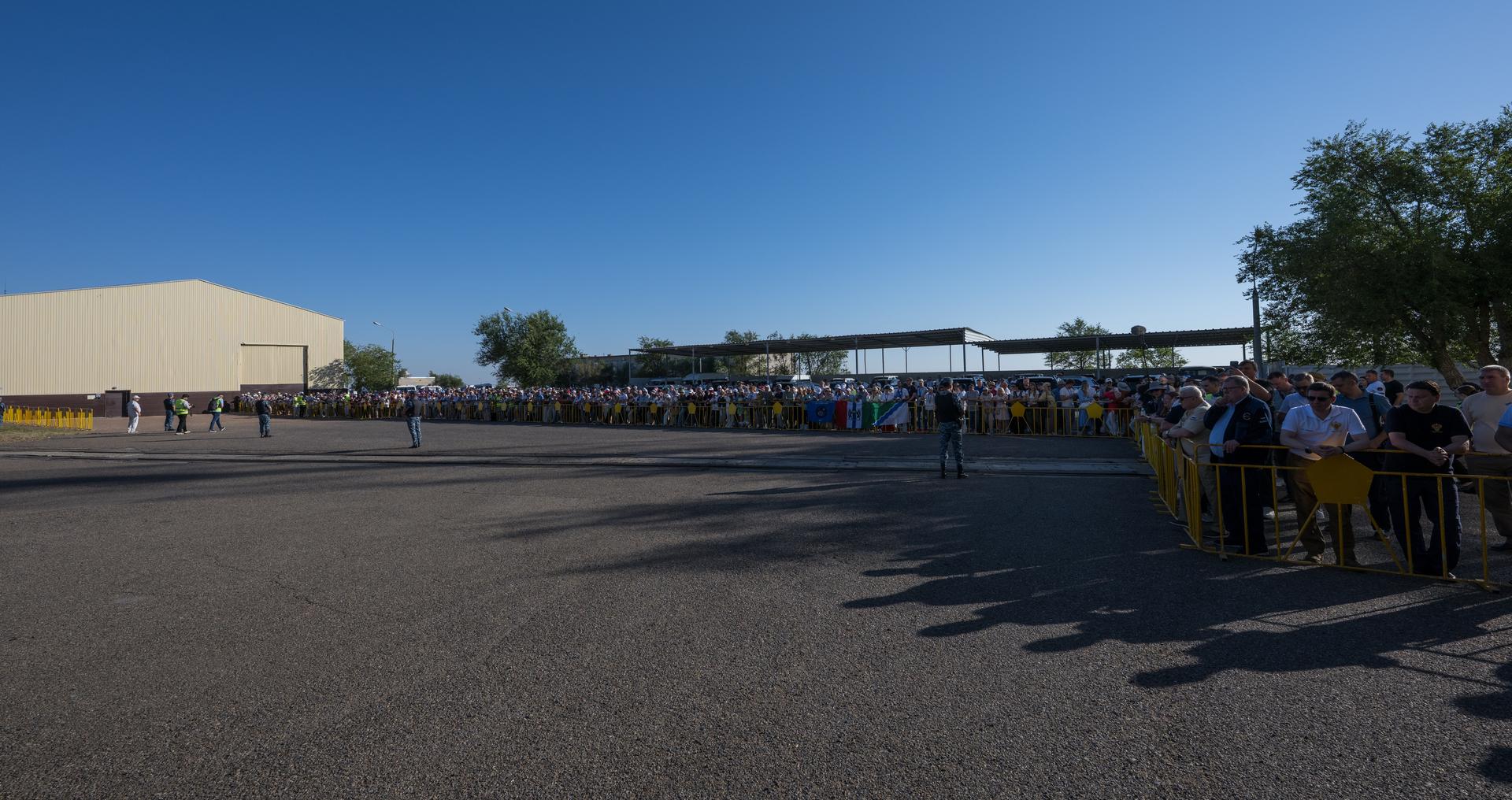 Crowds watch as the Soyuz rocket is rolled out by train to the launch pad, Saturday, July 11, 2026, at Site 31 of the Baikonur Cosmodrome in Kazakhstan. Expedition 75 crewmembers: NASA astronaut Anil Menon, Roscosmos cosmonauts Pyotr Dubrov and Anna Kikina are scheduled to launch aboard their Soyuz MS-29 spacecraft on July 14. Photo Credit: (NASA/Bill Ingalls)